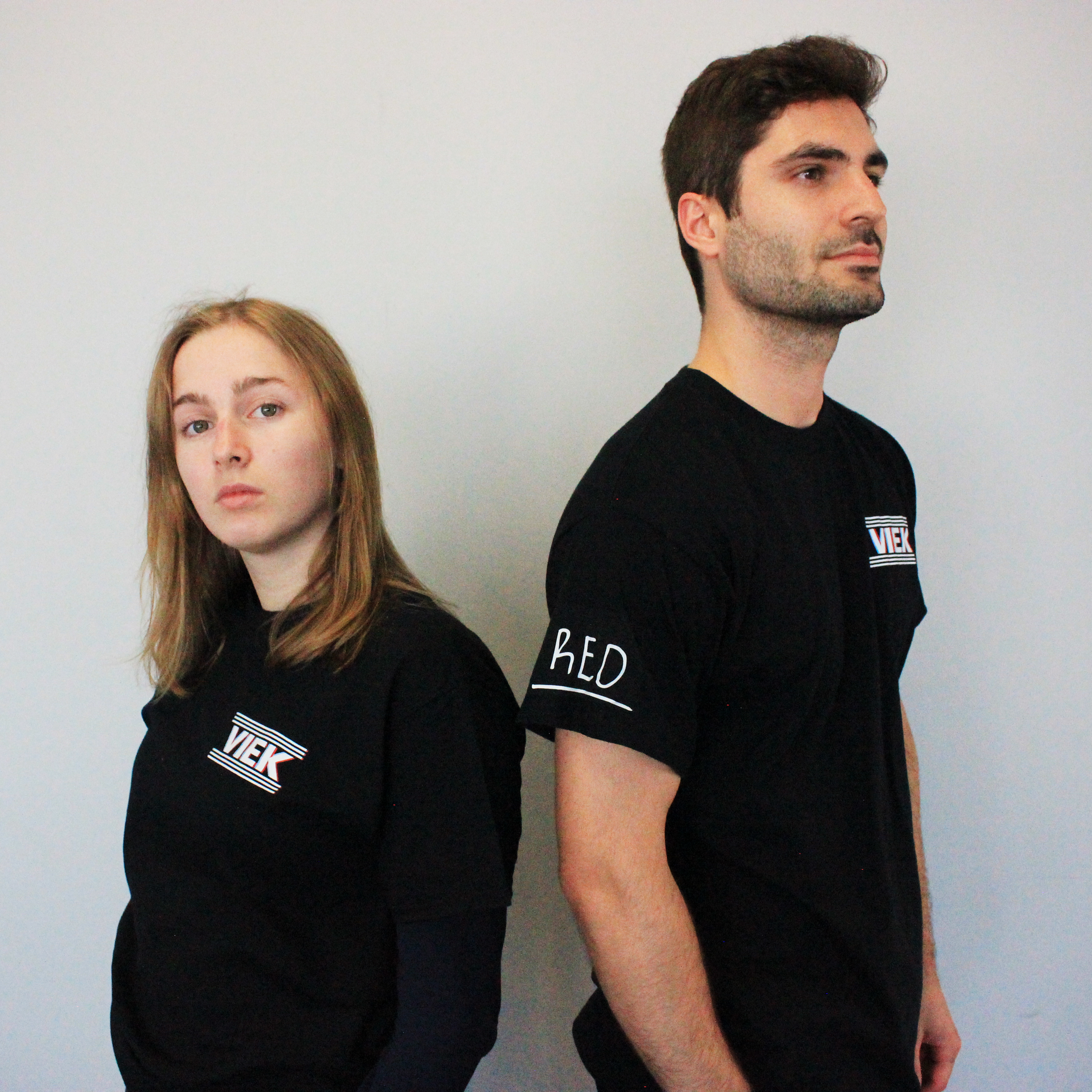 A young woman and a young man posing for the merch