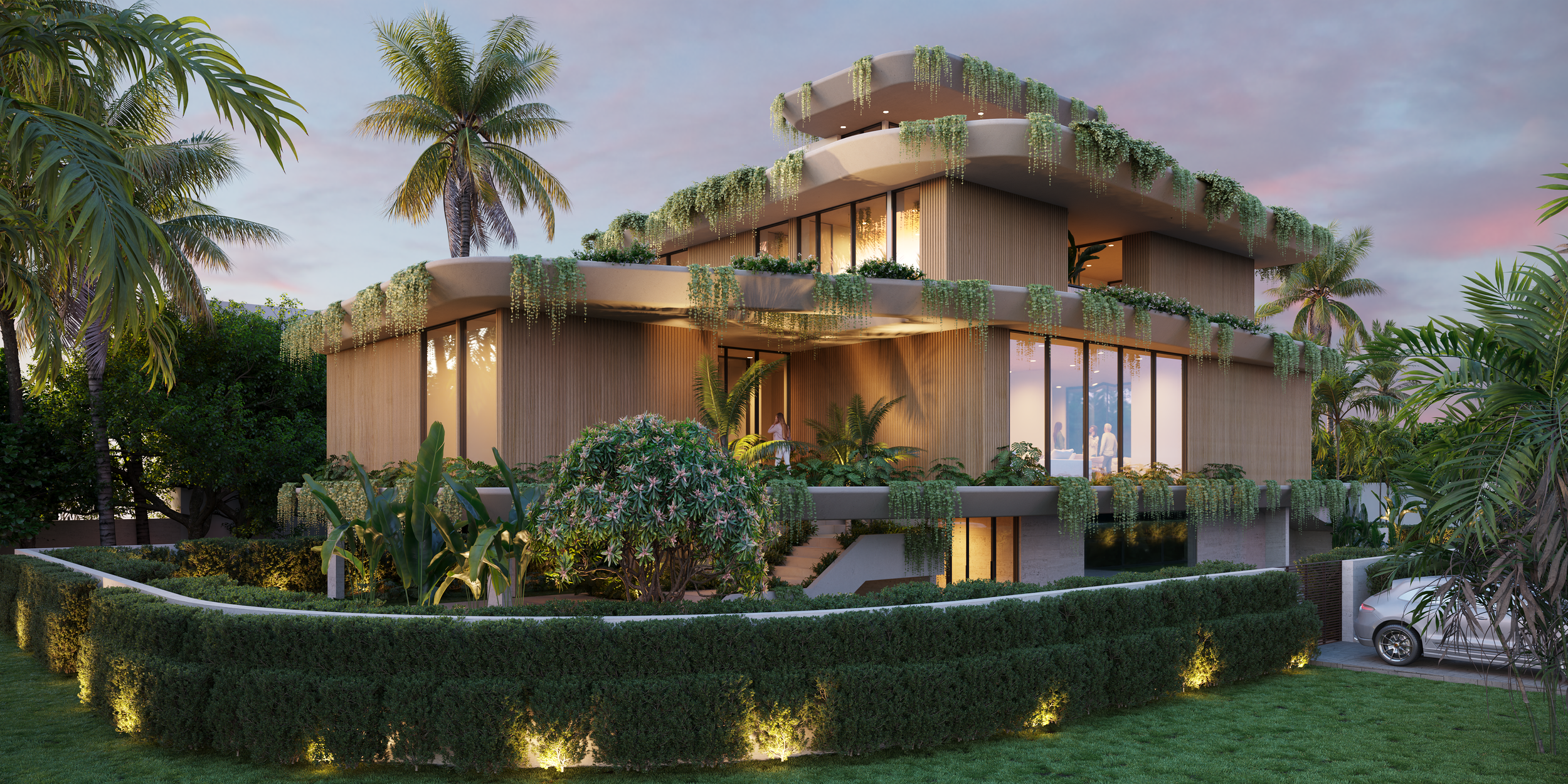 Modern multi-story house surrounded by lush tropical plants and palm trees during sunset, with large glass windows and outdoor lighting.
