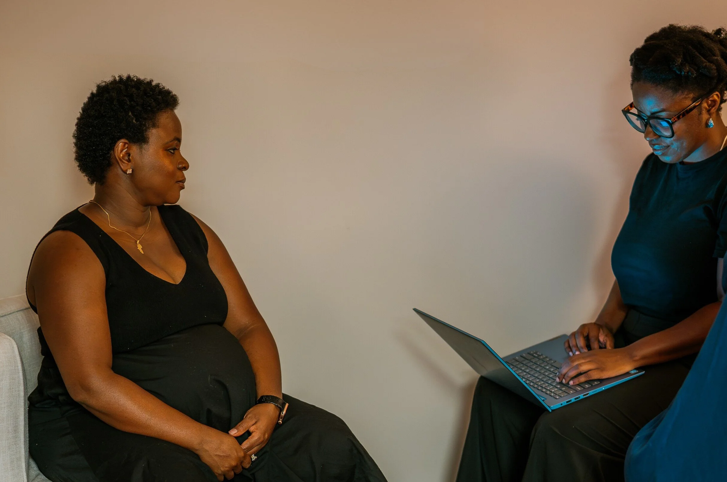 A close-up of a woman's hand holding a baby's tiny foot, showing both of their skin textures and details.
