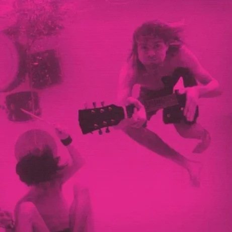 Two children sitting on the floor, one playing an acoustic guitar, with a pink filter over the entire image.