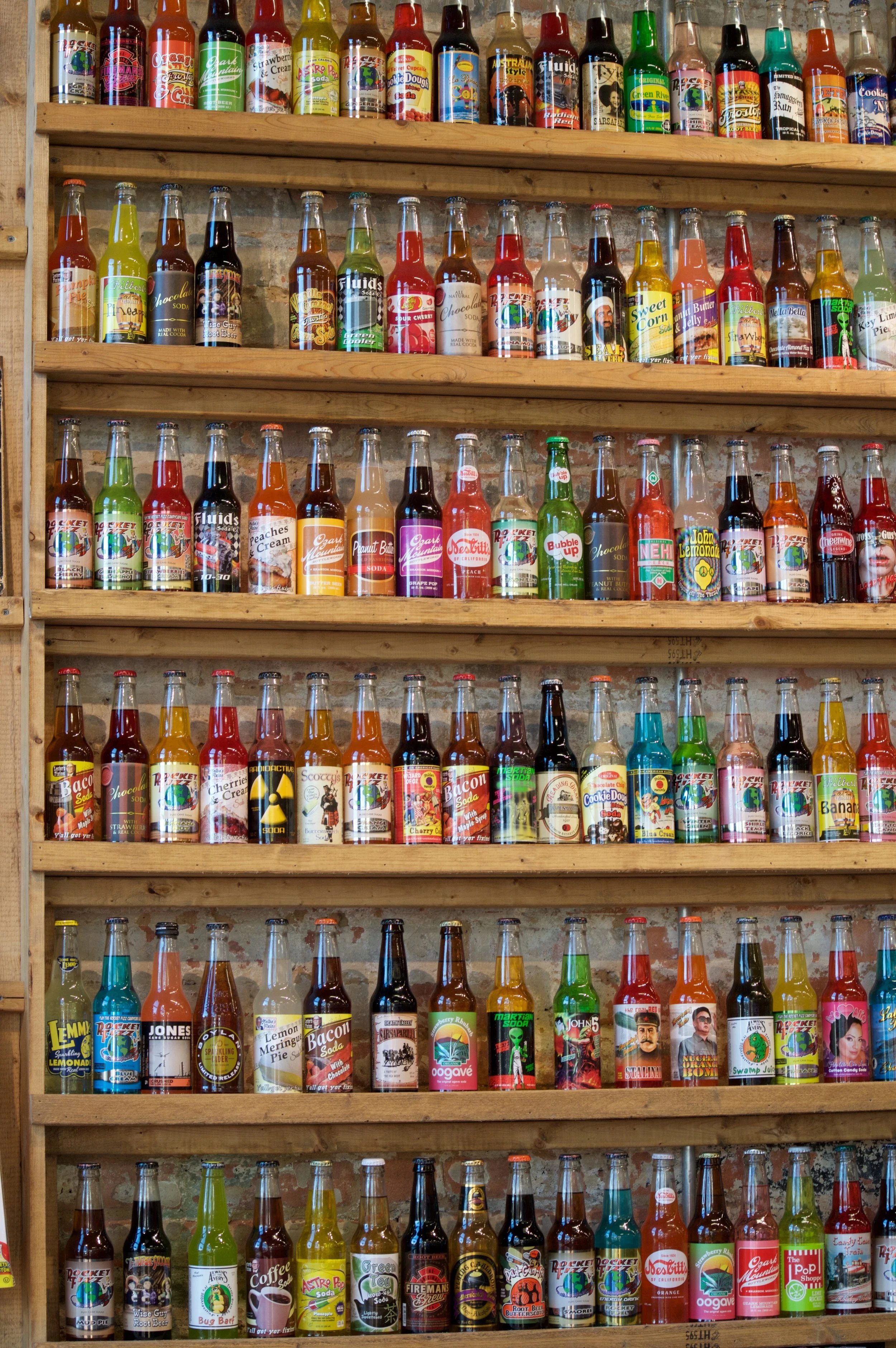 Shelves filled with colorful, uniquely labeled soda bottles.
