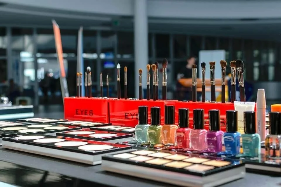 Assorted makeup products including nail polishes, brushes, and palettes on display.