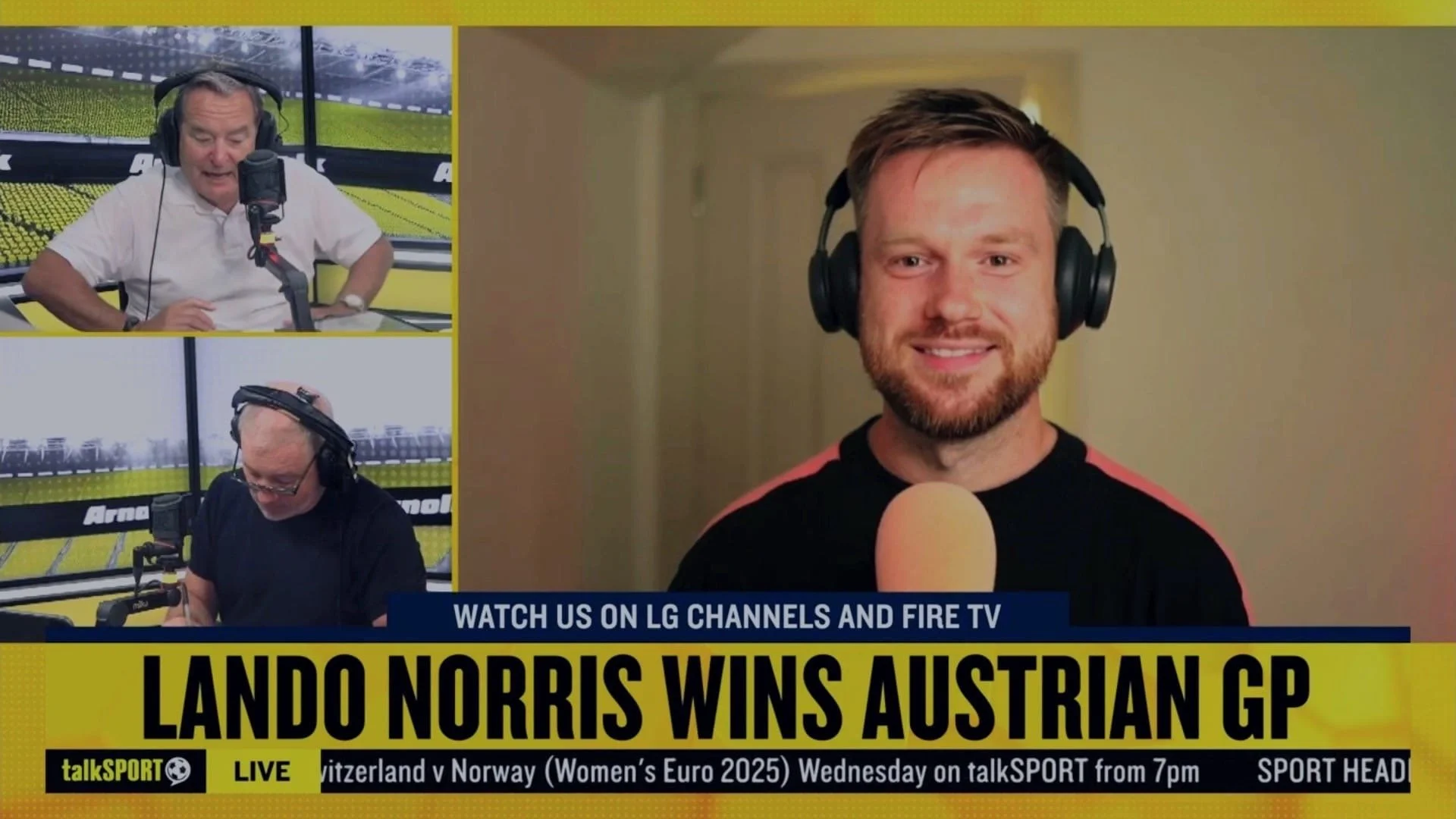 Split-screen image of three sports commentators with headphones, discussing a racing event. The main speaker on the right is a smiling man with a beard, wearing a black shirt with red accents, speaking into a microphone. The top left shows an older man in a white shirt with hand on his hip, and the bottom left features another man in a black shirt, looking down. The caption reads, 'Lando Norris wins Austrian GP' with additional text about broadcasting on talkSPORT.