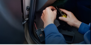 Person working on a car's interior wiring with a screwdriver
