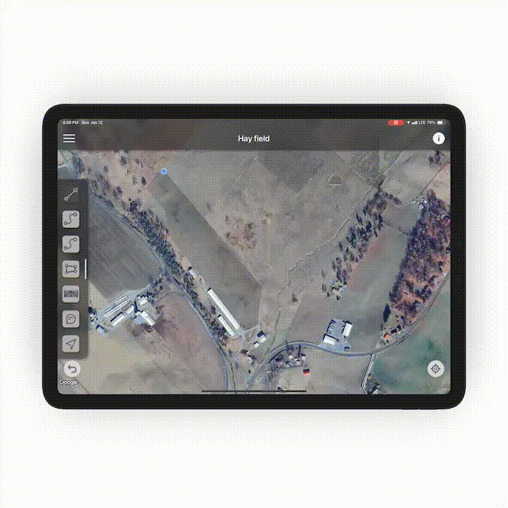 Digital tablet displaying an aerial map of Hay Field with fields, buildings, and roads.