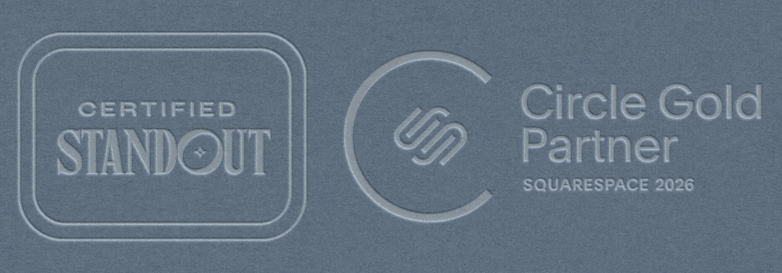 Embossed logos on blue paper. Left: "Certified Standout" in a frame. Right: Stylized "S" in a circle, text reads "Circle Gold Partner, Squarespace 2026."