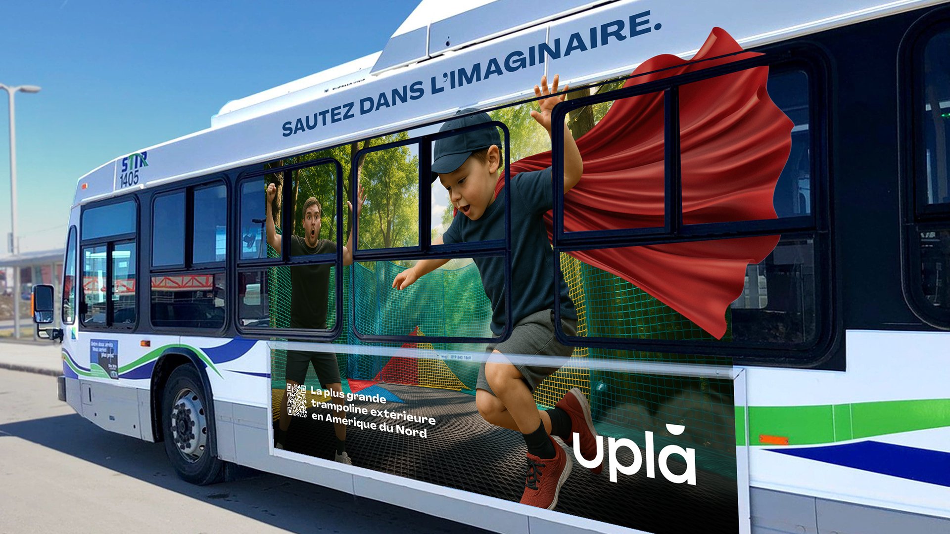A promotional bus with children playing on a trampoline inside, with one child jumping and another reacting with surprise, advertising the largest outdoor trampoline in North America.
