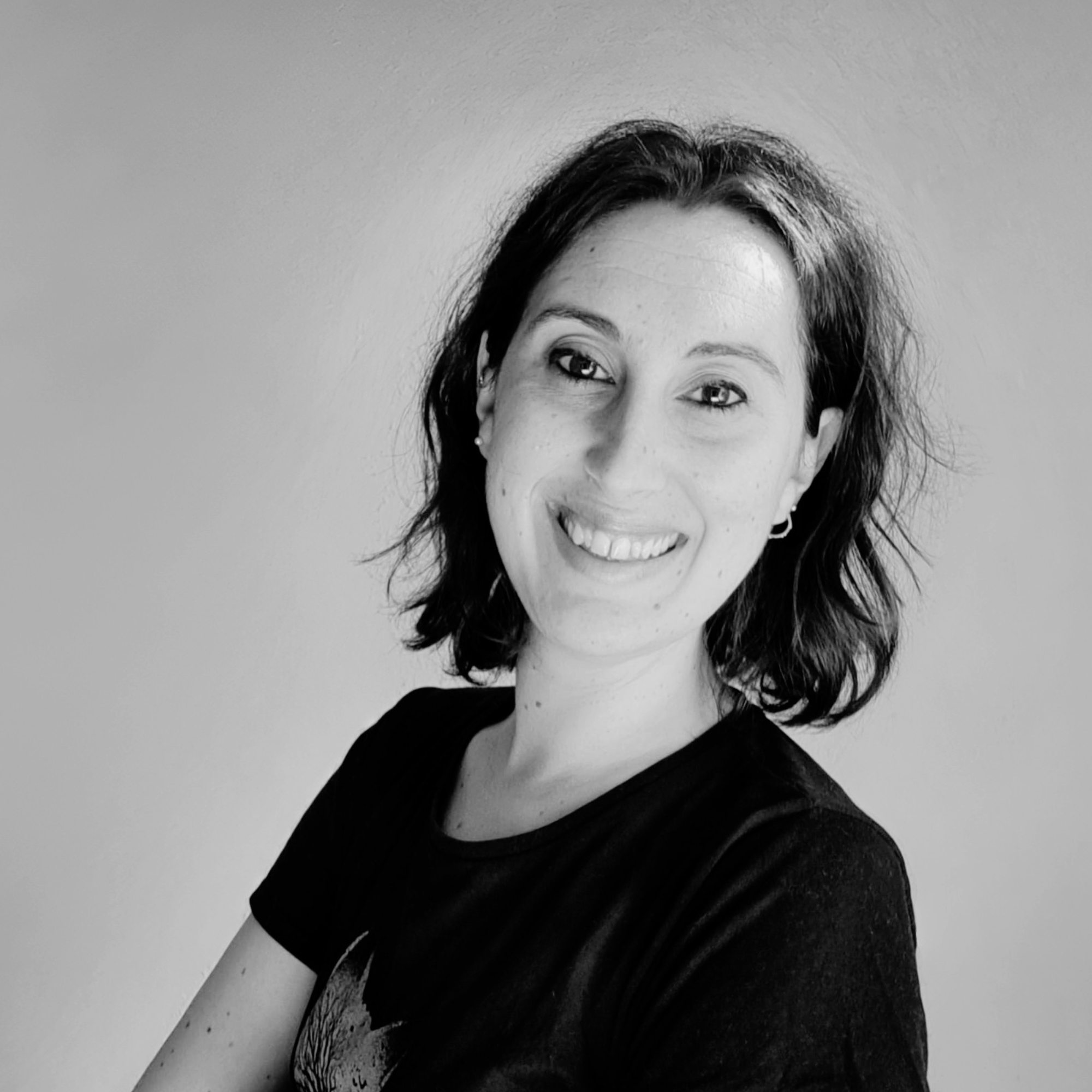 Retrat en blanc i negre d’una professional de Vitalik Lab somrient a càmera, amb cabell curt i samarreta negra, sobre un fons llis. La imatge transmet proximitat, professionalitat i confiança.
