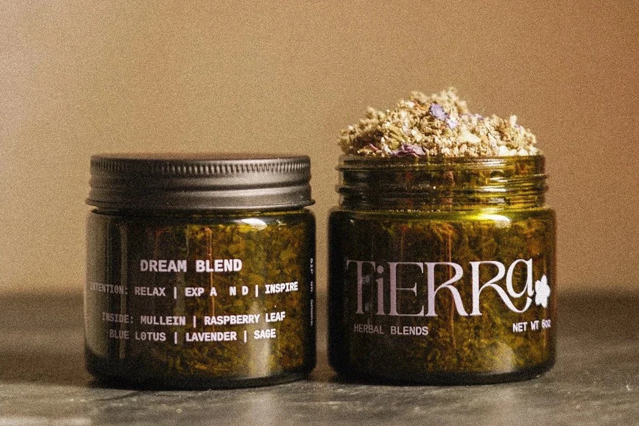 Two labeled jars of herbal blends; one jar has herbs overflowing, the other jar is closed.