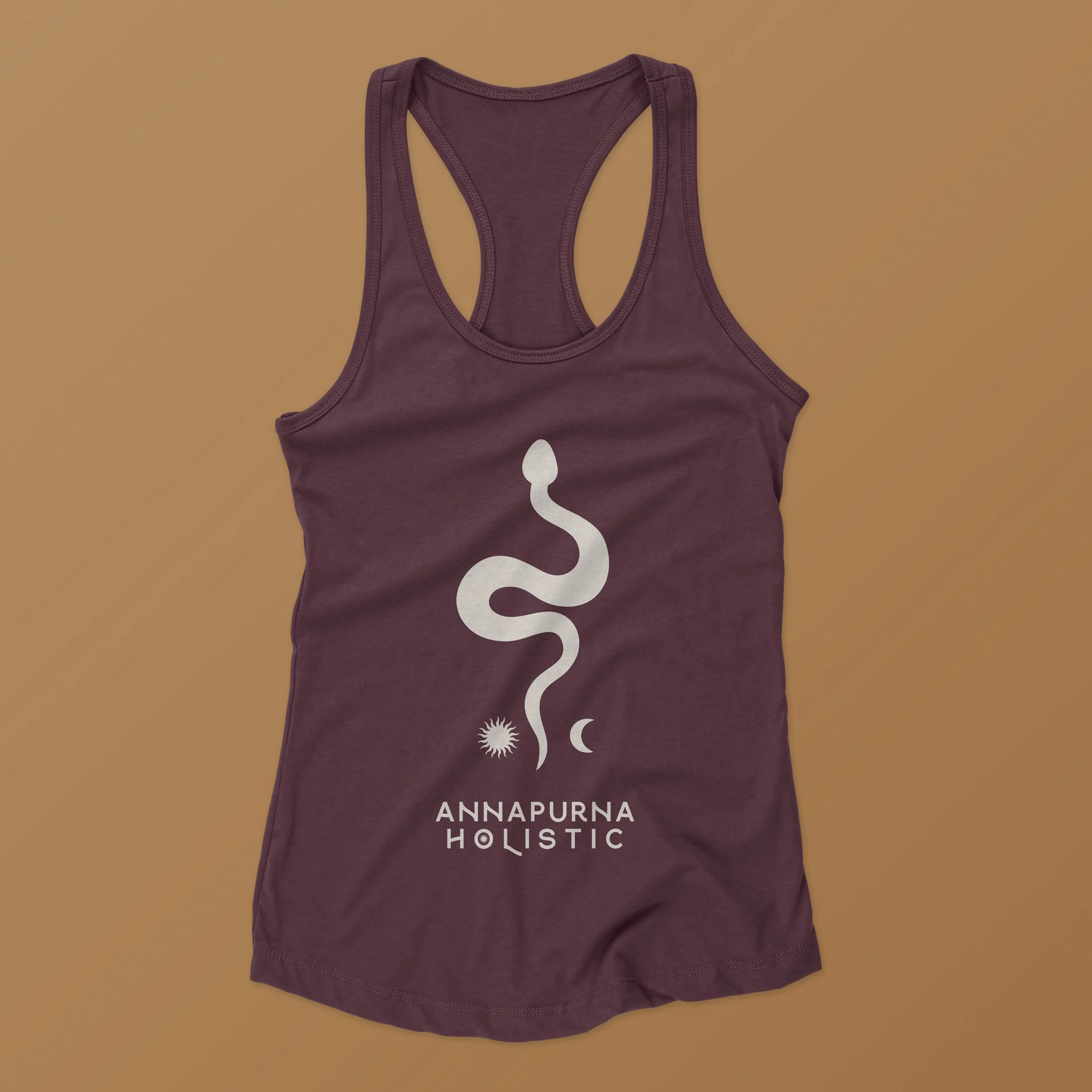 Purple tank top with snake and celestial symbols and the text 'Annapurna Holistic' printed on the front.