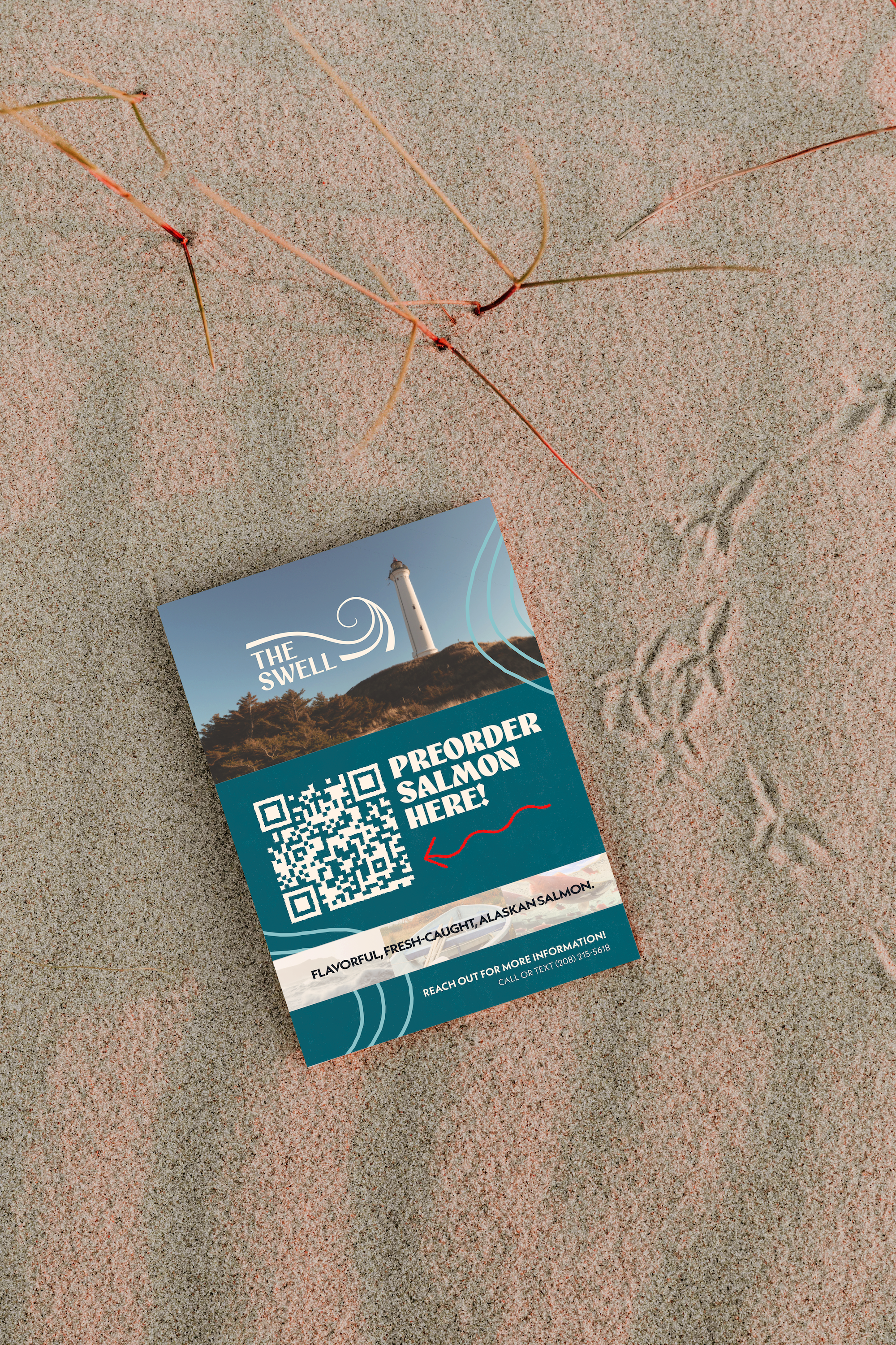 A promotional card advertising Alaskan salmon with a lighthouse in the background, placed on sandy beach along with some seaweed and footprints.
