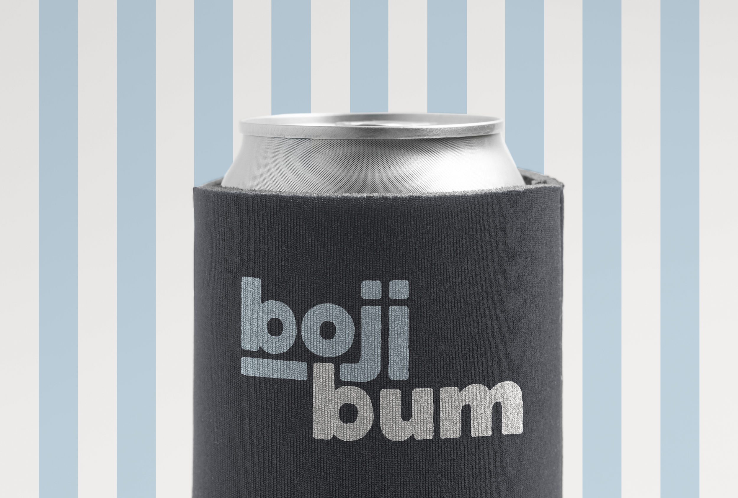 A soda can inside a black neoprene drink koozie with light blue and white striped background.