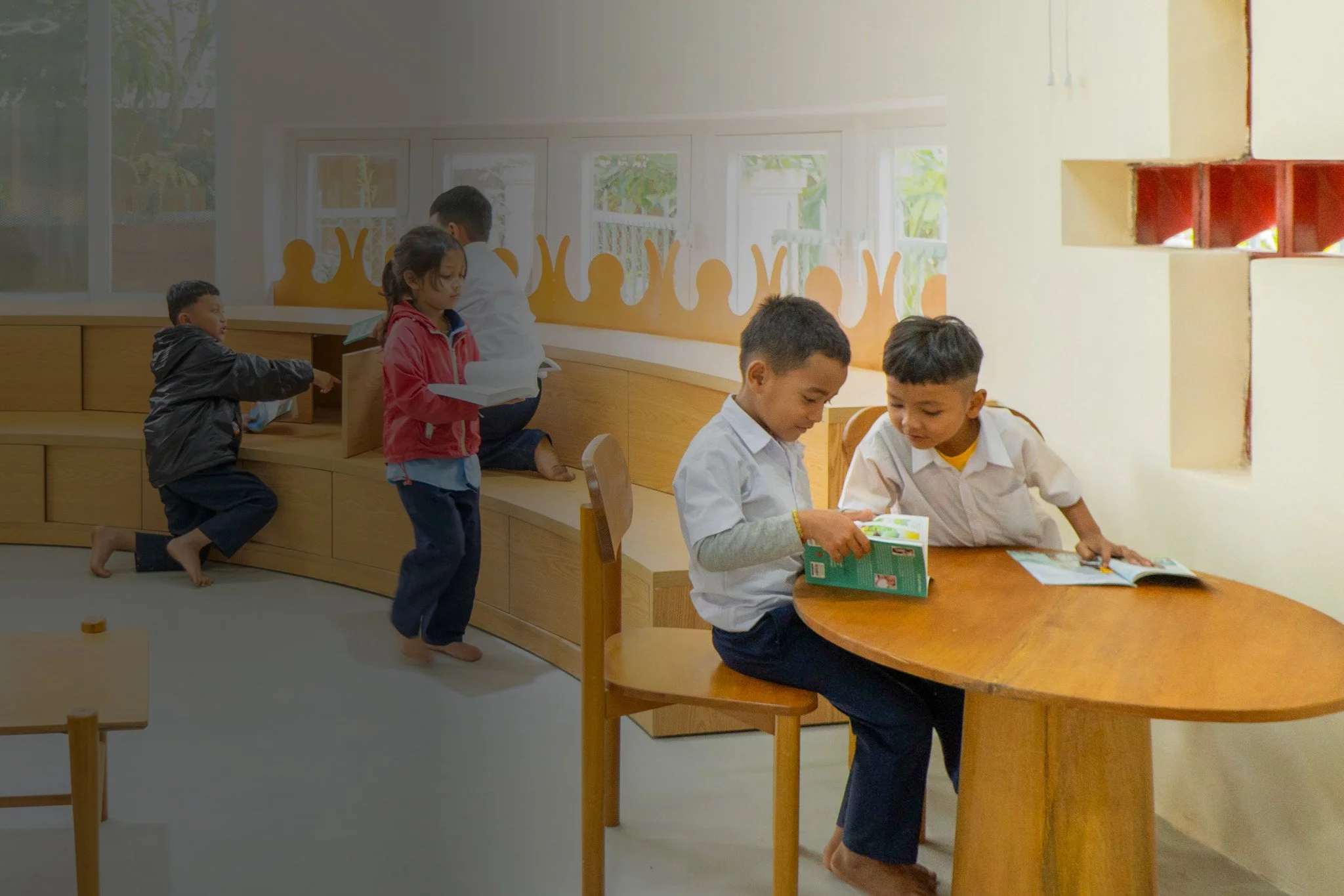 Two young boys read a book in a learning corner.