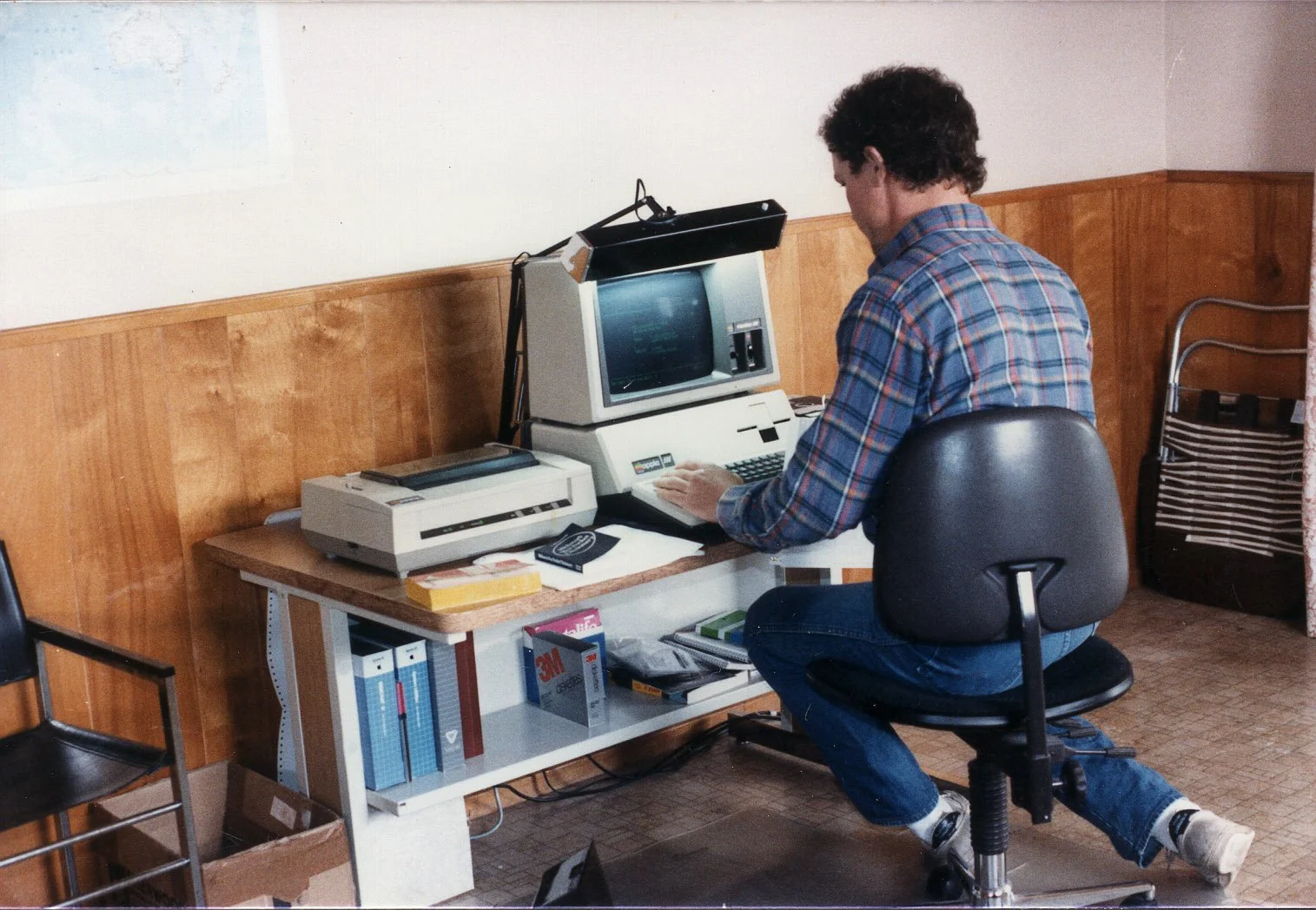 A person responding to messages at a computer, a reminder that every era has its version of cutting edge.