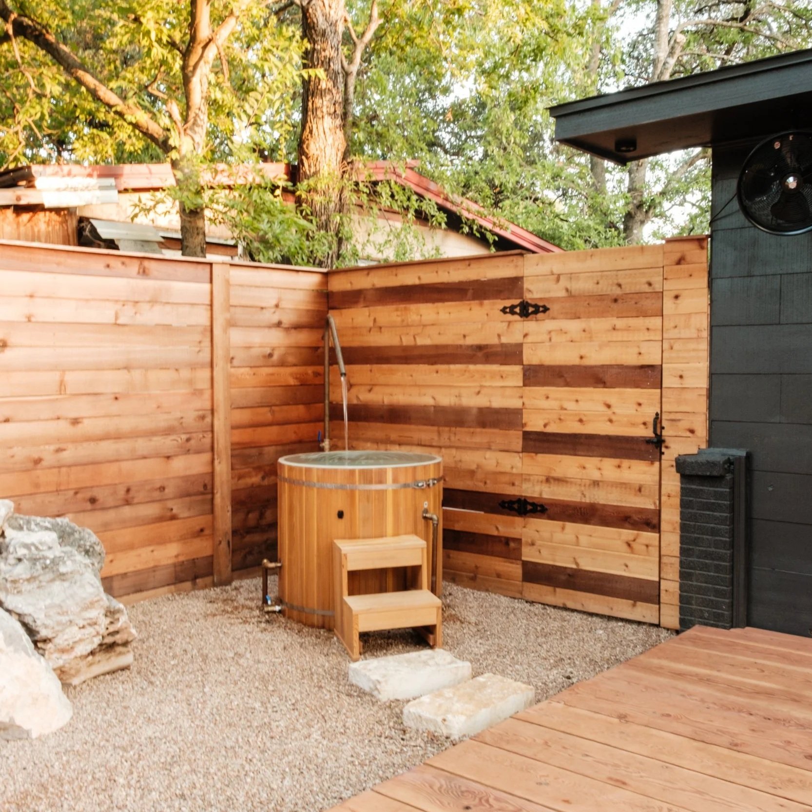 Outdoor wooden cold plunge tub integrated into a private backyard space.