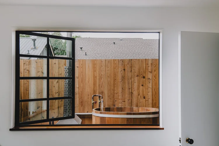Indoor cedar soaking tub with steel window, Austin