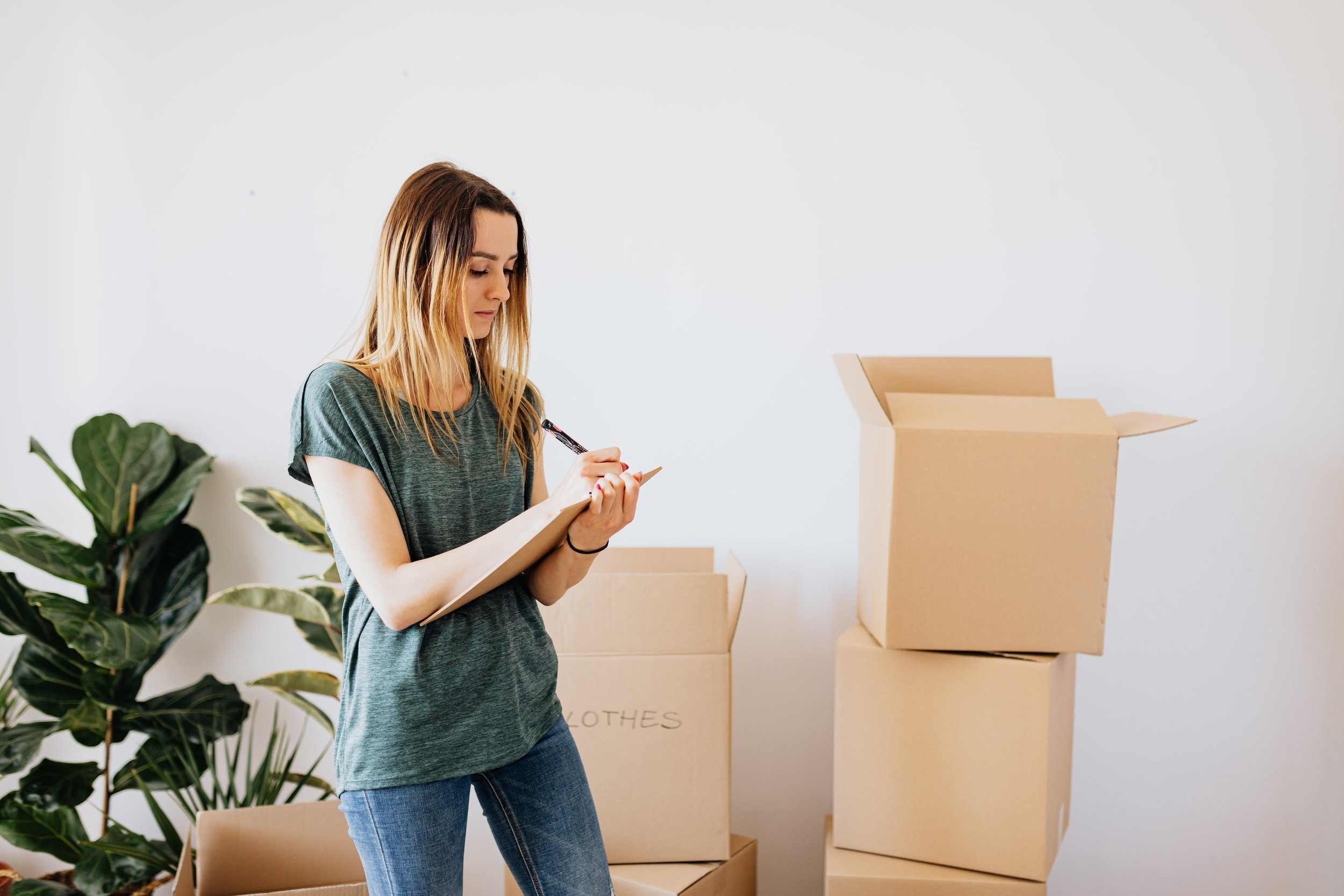 A woman packing boxes during the declutter and donate step of organizing.