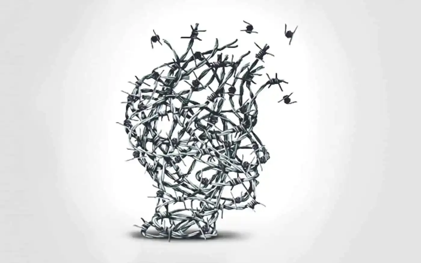 A person wearing a beige knit glove holding a black and white speckled mug filled with tea. In the background, there are dried wheat stalks and plates on a wooden surface.