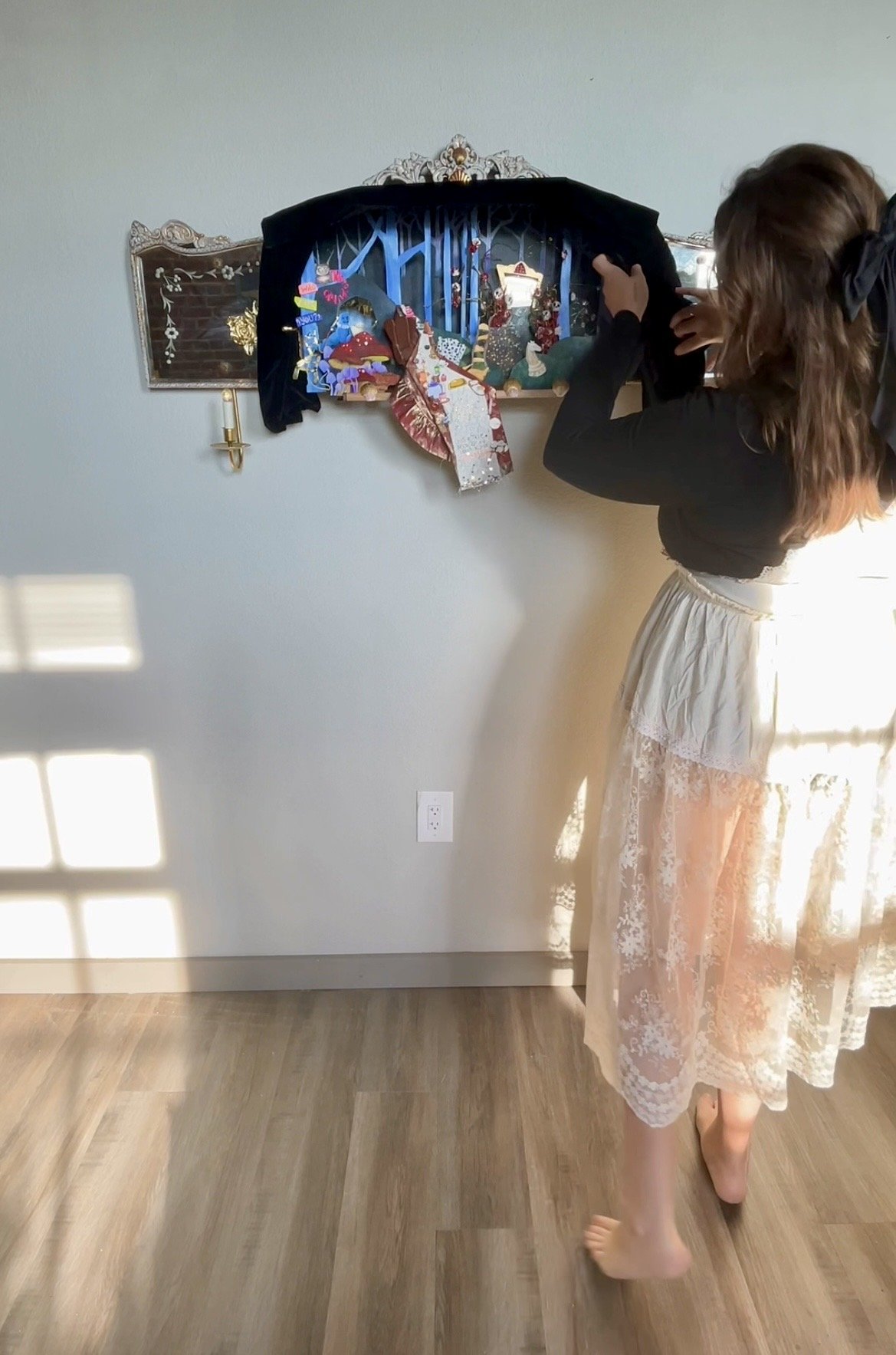 This piece is assembled on a mirror with candles, curtains, and a stage for the story to play out