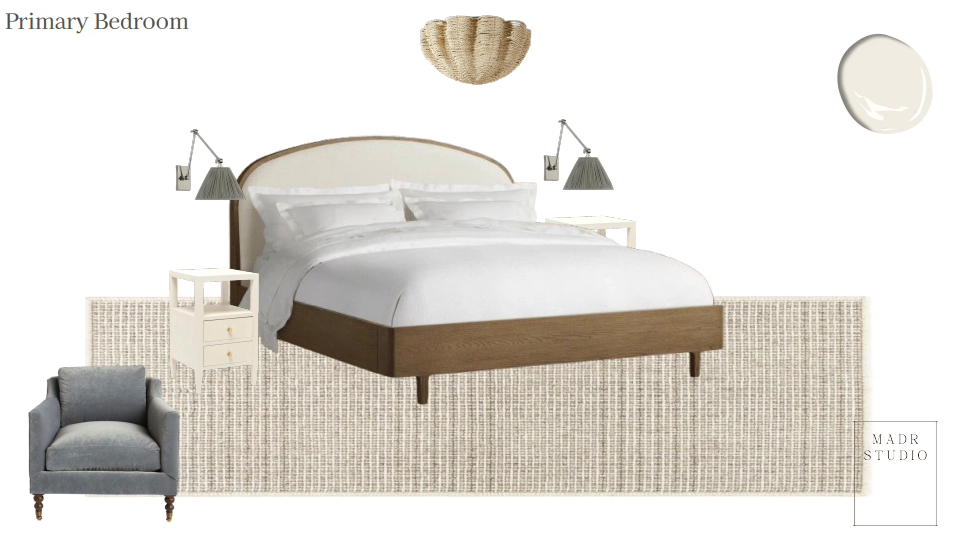 A bedroom with a large bed, white bedding, two nightstands with lamps, a gray armchair, a textured area rug, a decorative wall hanging, and a circular wall mirror.