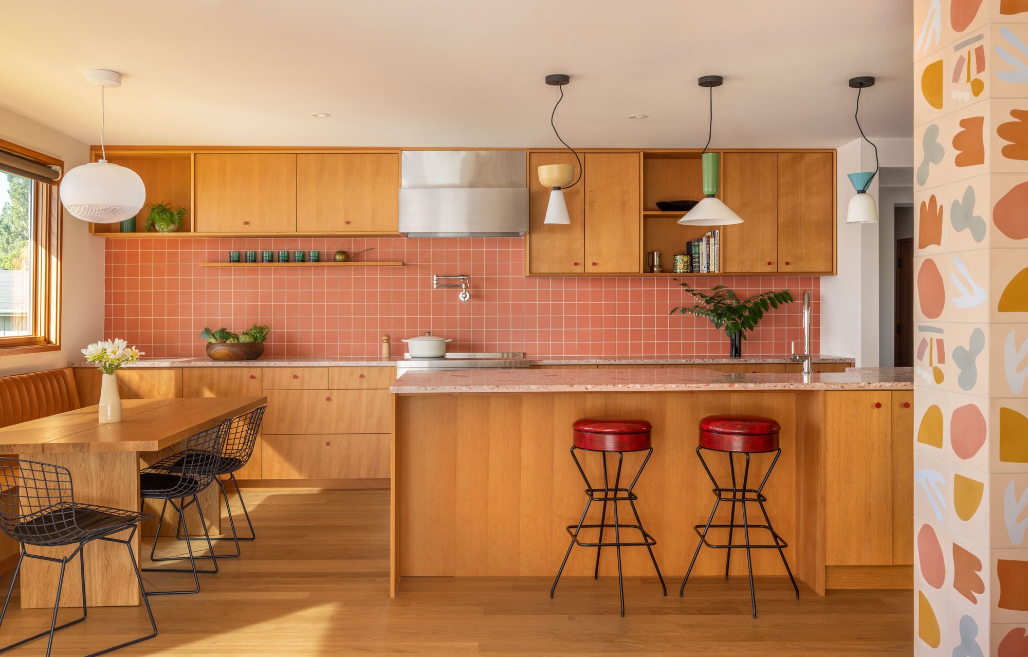 New, reoriented kitchen with custom fir cabinetry and banquette, Concrete Collaborative countertops, and Zia Tile backsplash.