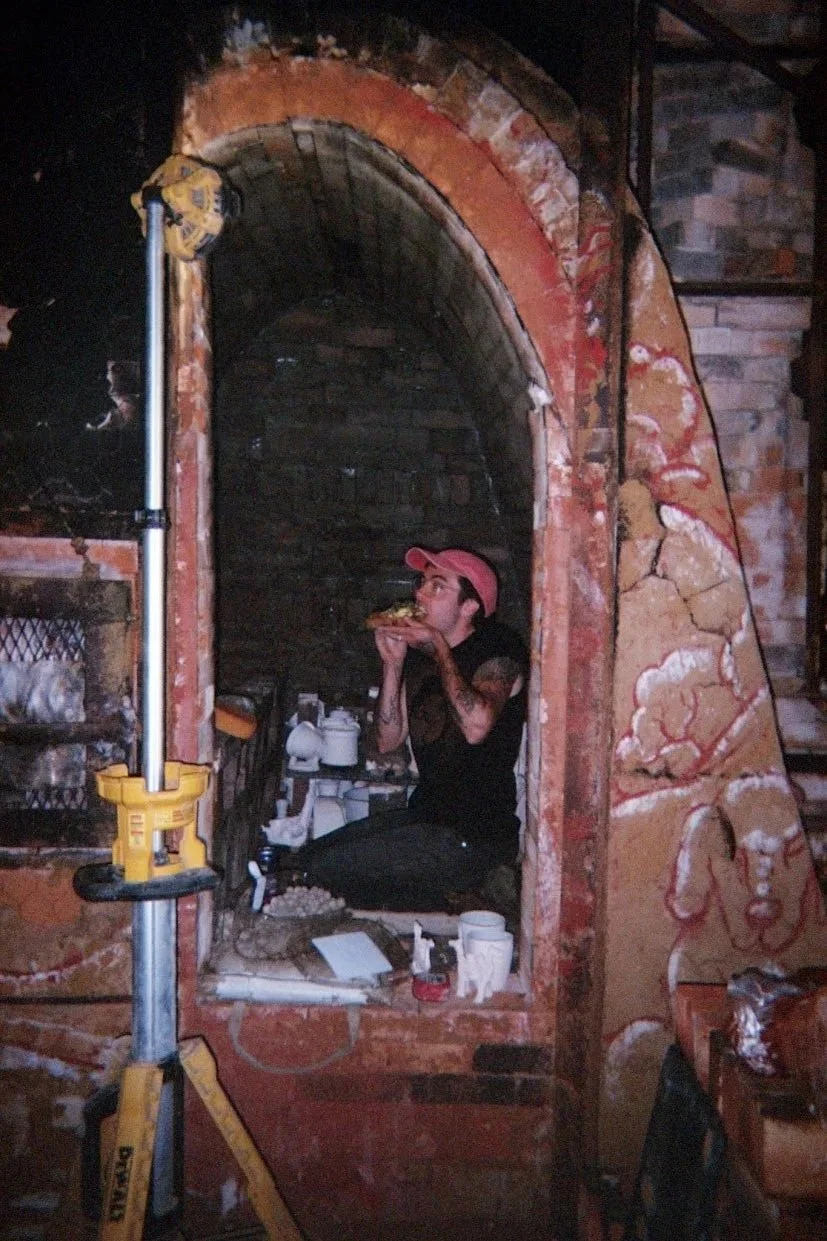 Dan eating big toast in the kiln. Disposable camera photo by Jules