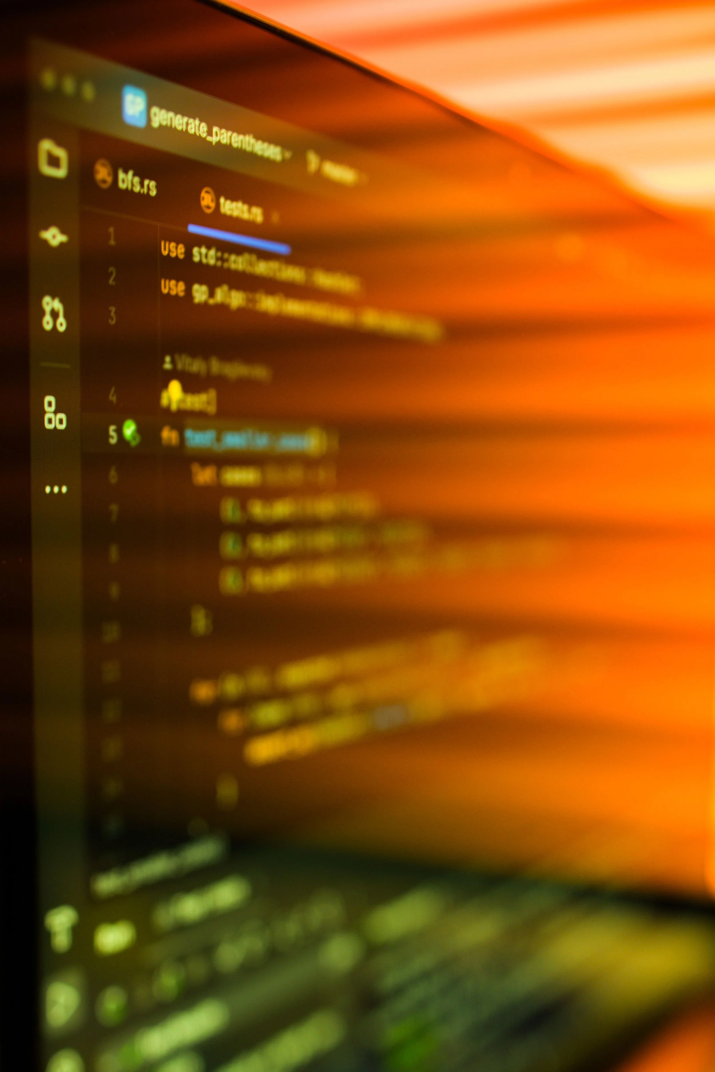 A blurred computer screen displaying text and icons, with a warm orange and yellow-toned background.