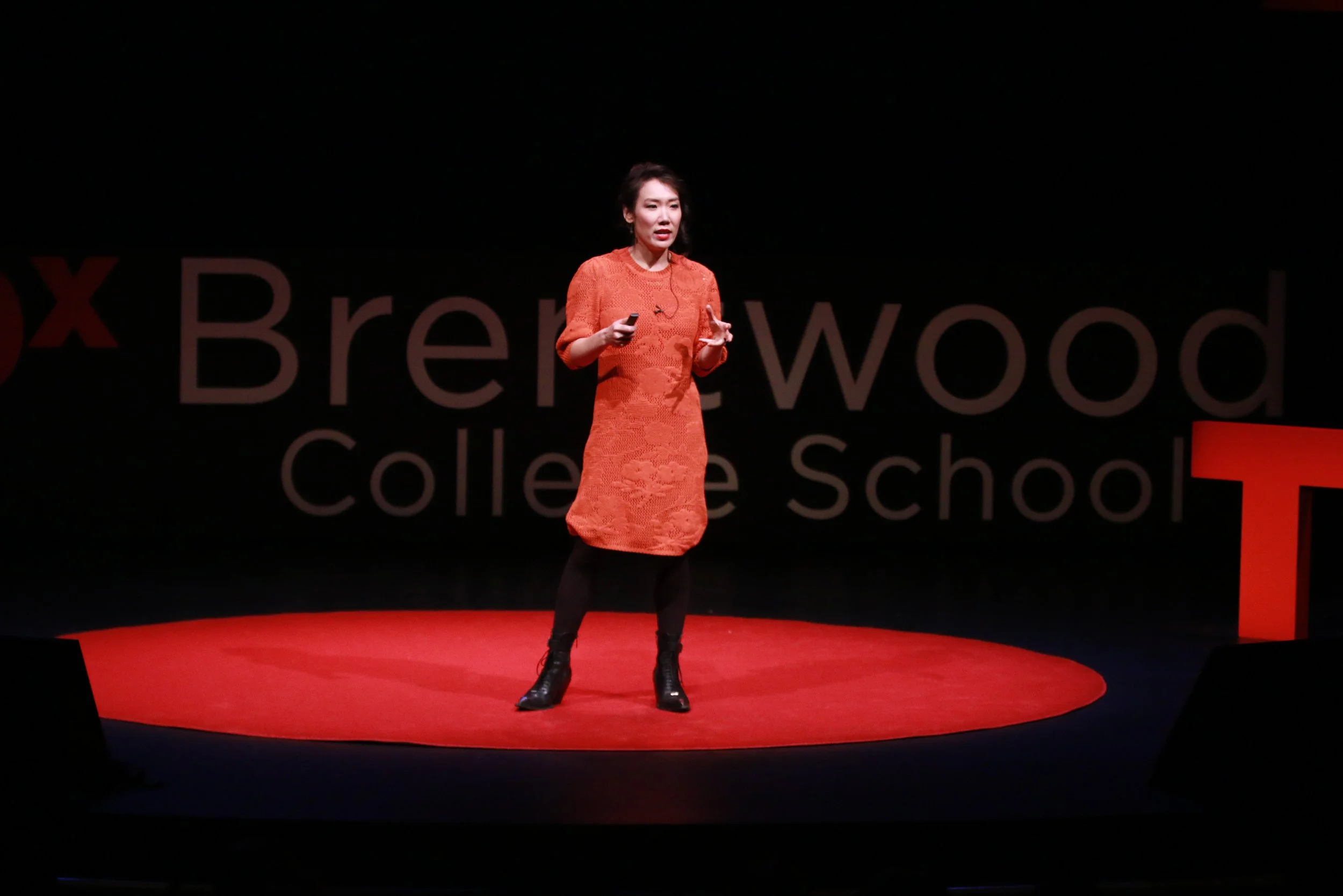 Pennylane Shen, artist advisor, giving a presentation on a stage at a TEDx event at Brennwood College School.