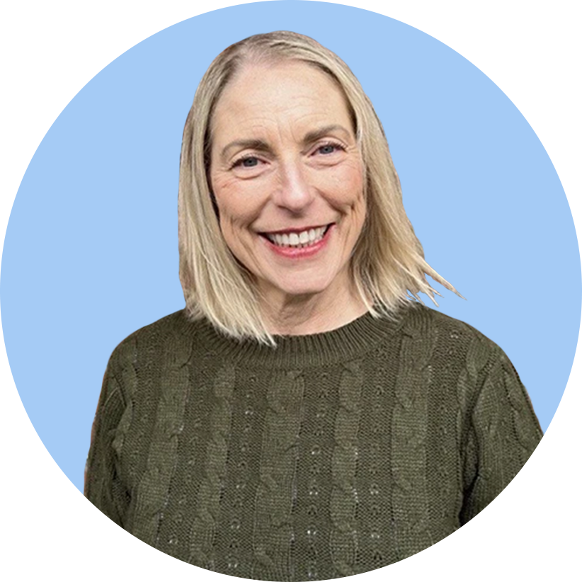 Smiling woman with blonde hair wearing a green sweater, against a split blue and black background.