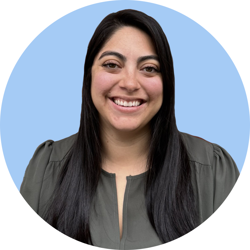 A woman with long black hair smiling at the camera, wearing a gray top, against a light blue background.