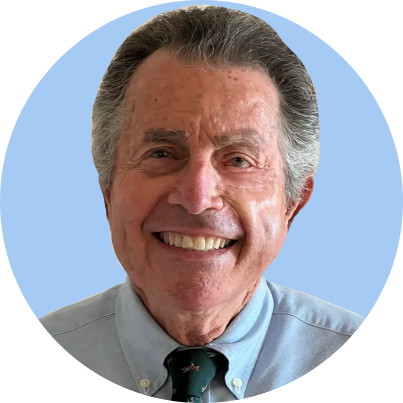 Smiling elderly man in a light blue shirt and patterned tie, with gray hair, in a digital avatar style.