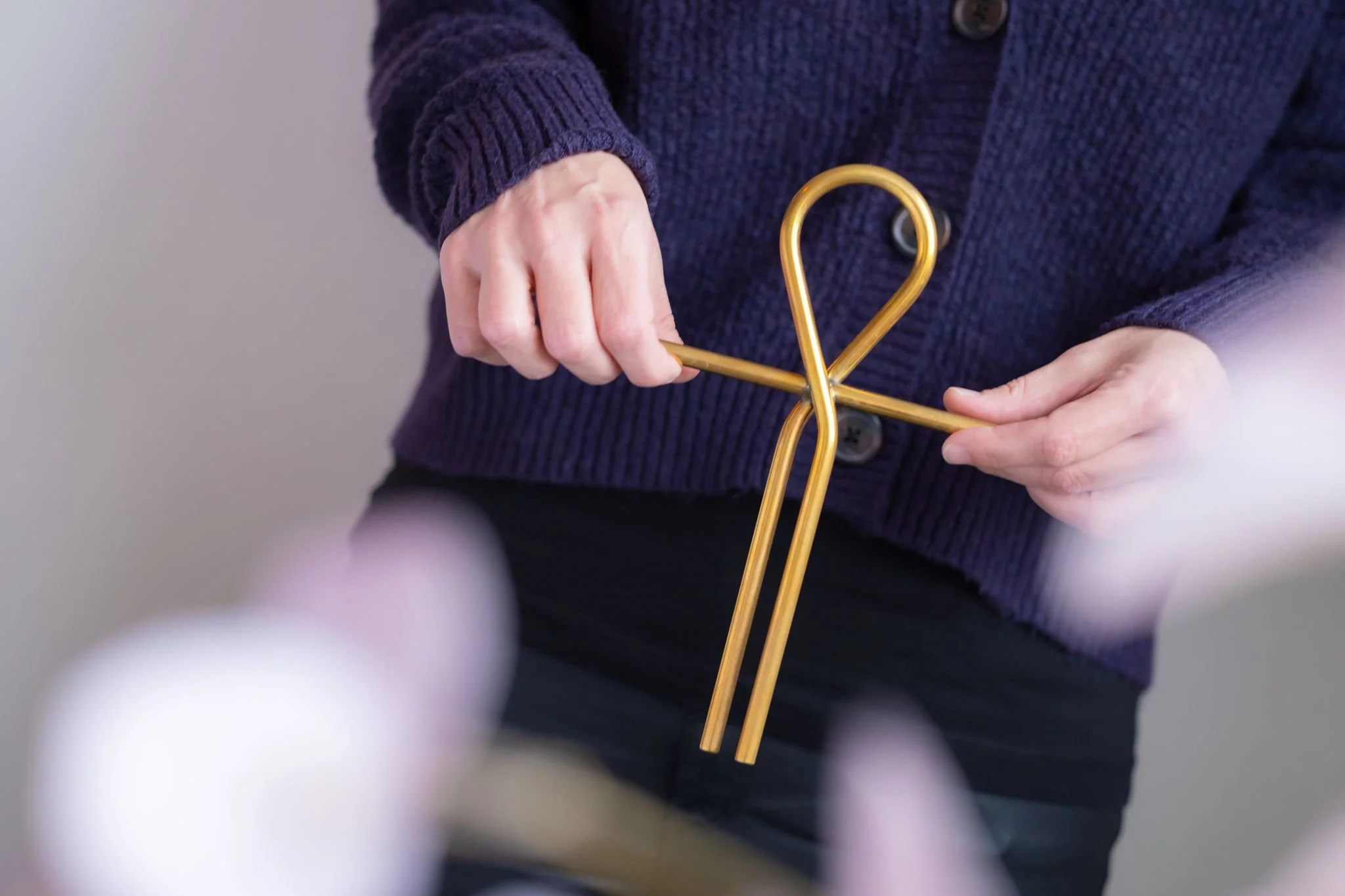 Persoon vasthoudt een goudkleurig figuurvormig object.