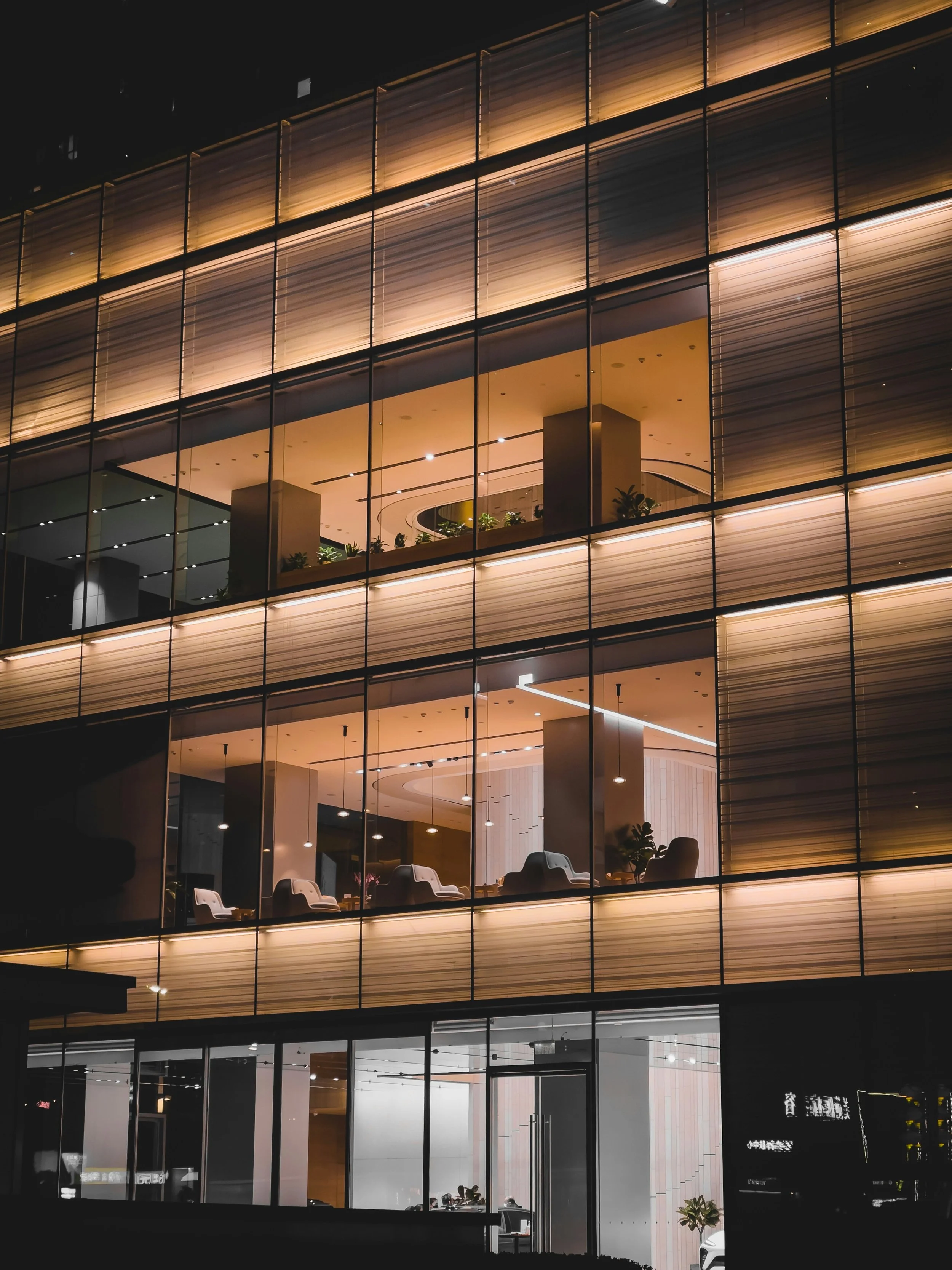 Interior view of a modern commercial office with floor-to-ceiling windows, high-end finishes, contemporary lighting, and ergonomic furniture.