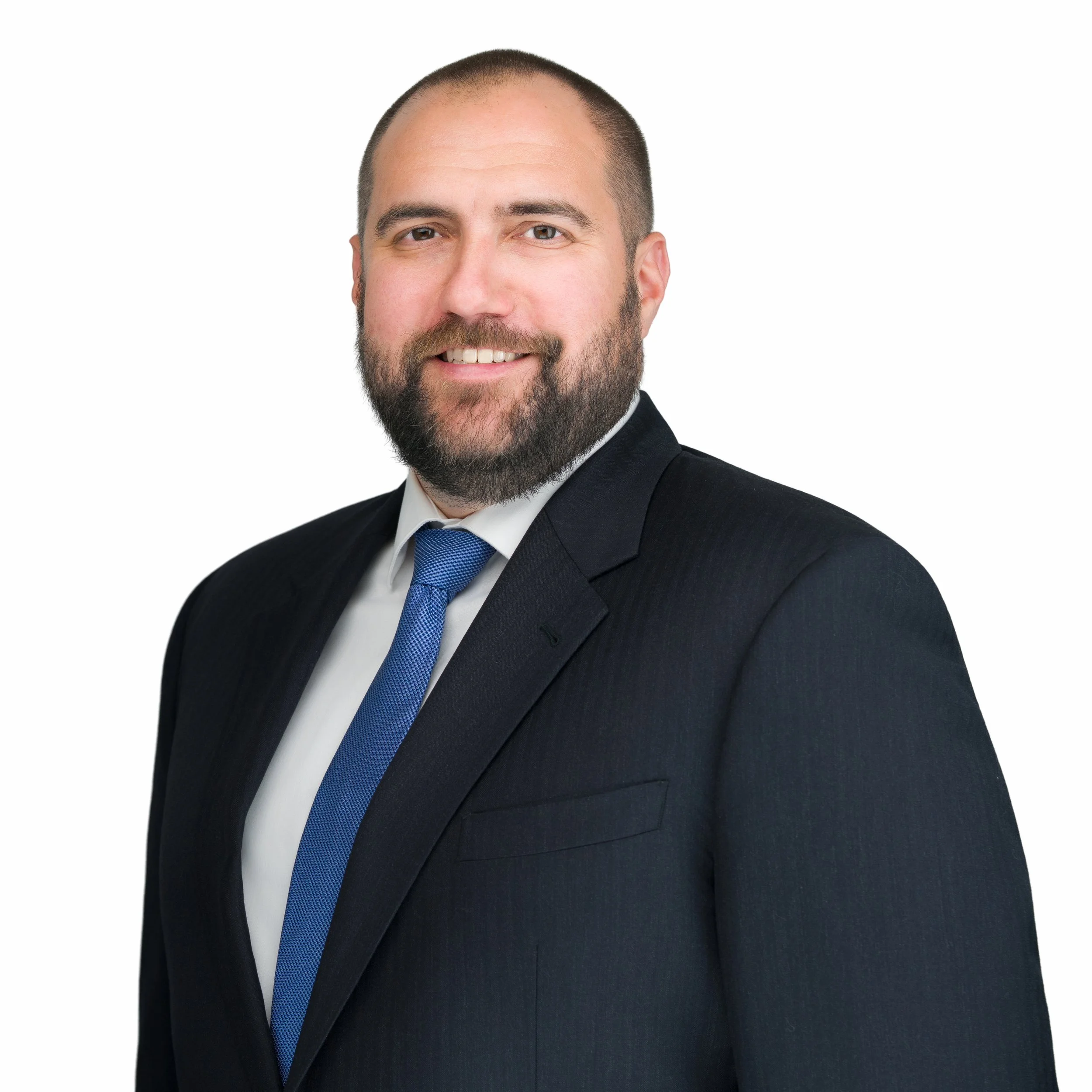 Image of Justin Hegedus wearing a black suit with a dark blue tie.