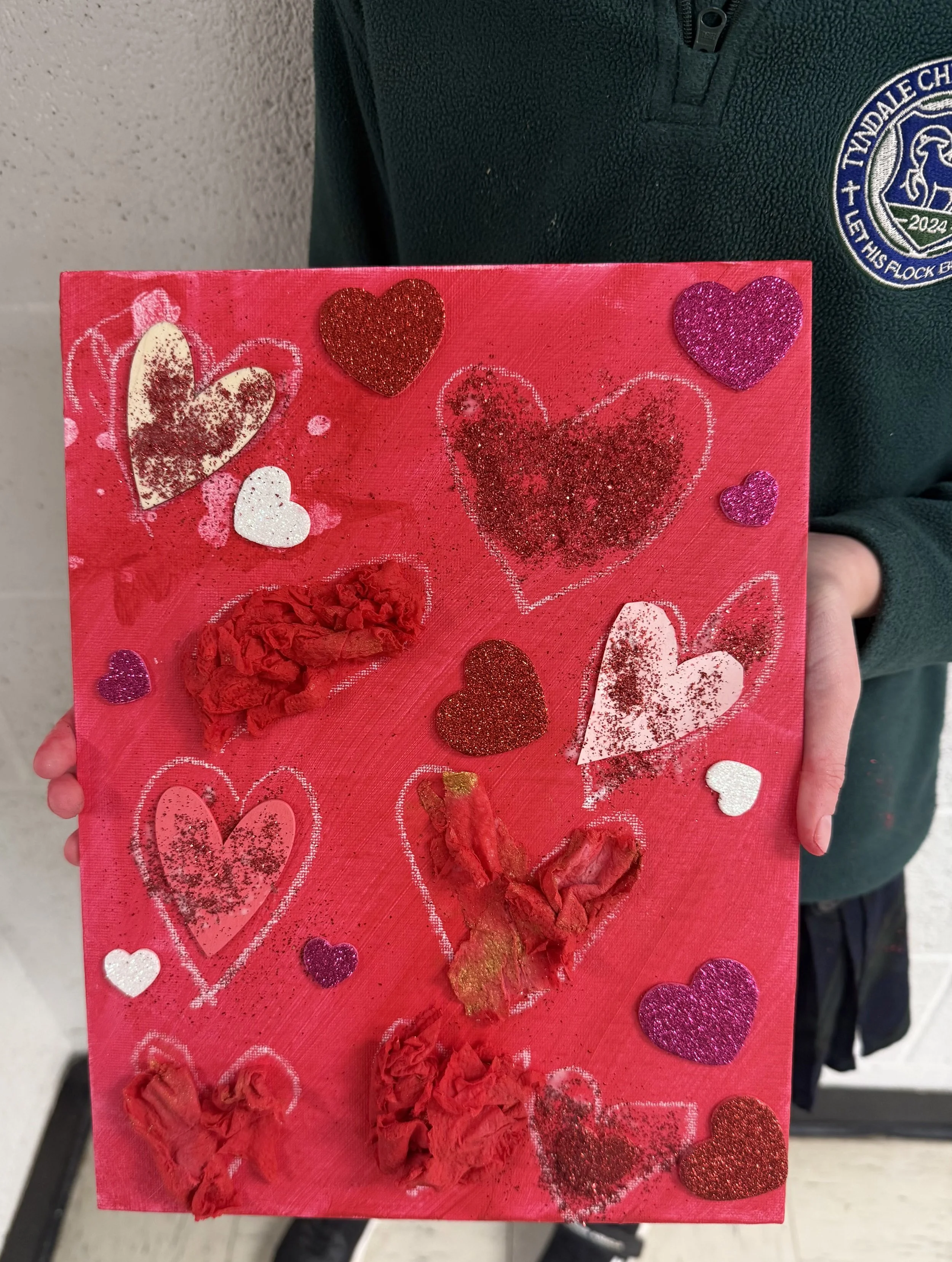 Red Valentine's Day card decorated with various hearts, glitter, and tissue paper.