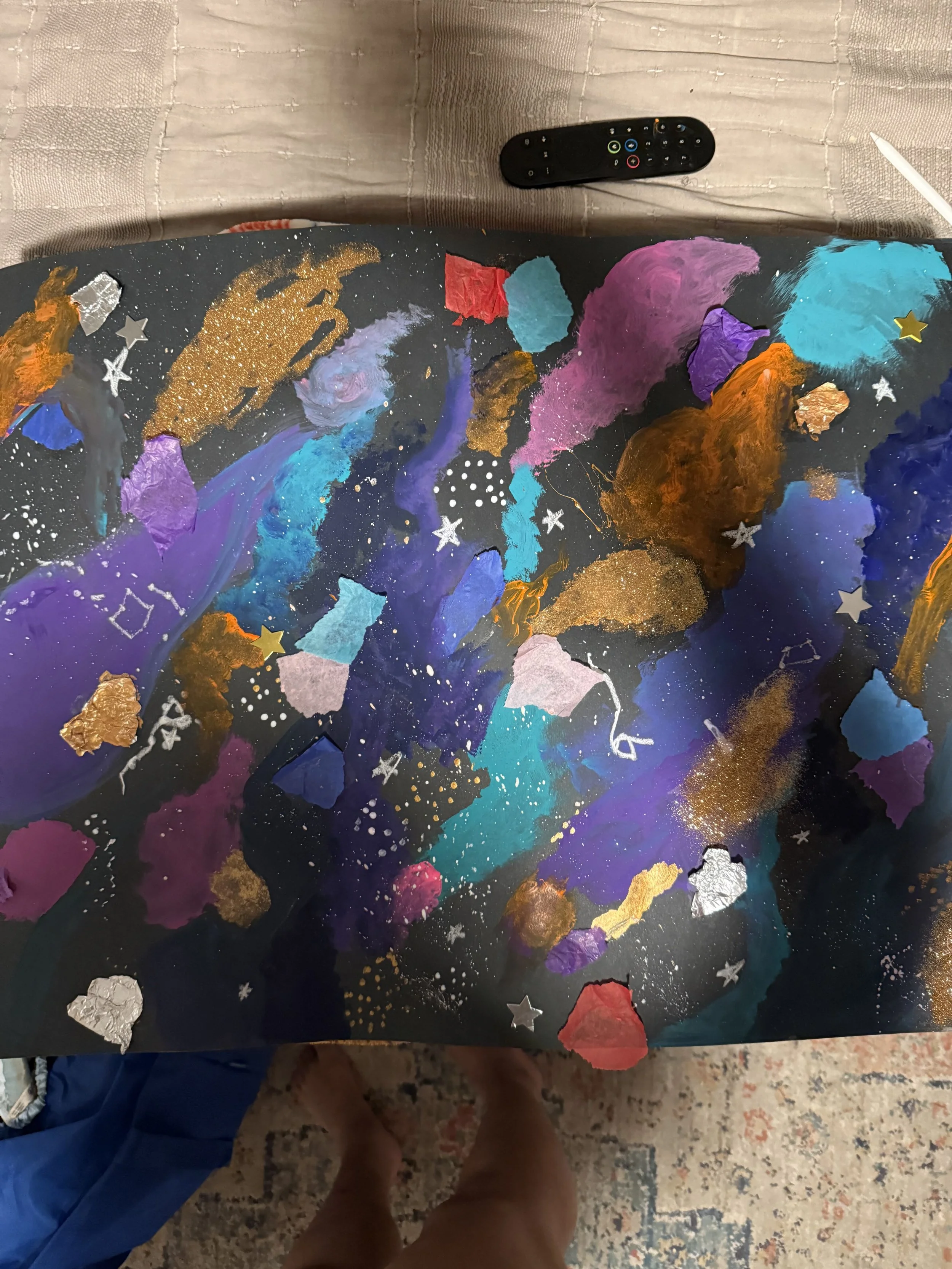 Abstract galaxy-themed painting with various colors, gold accents, and star stickers on a black background.