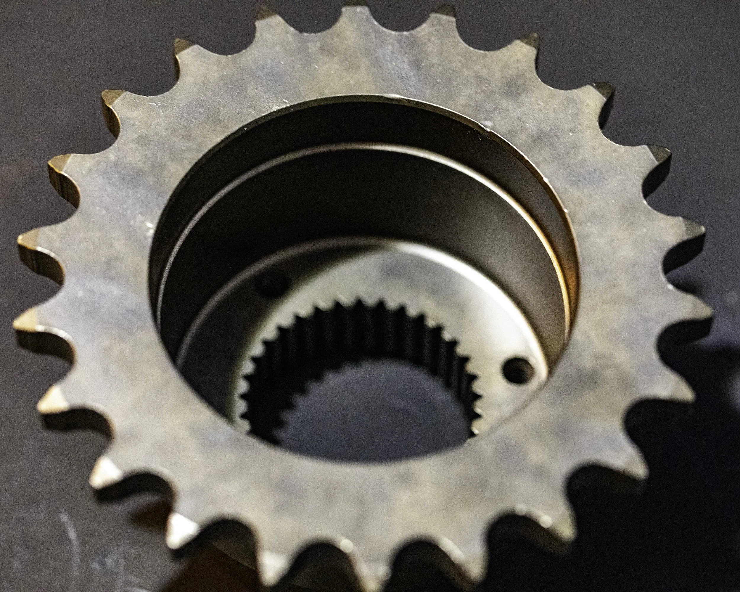 Close-up view of a metal sprocket with interlocking teeth, seen from above. Harley Davidson
