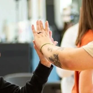 Close up image of two hands high-fiving