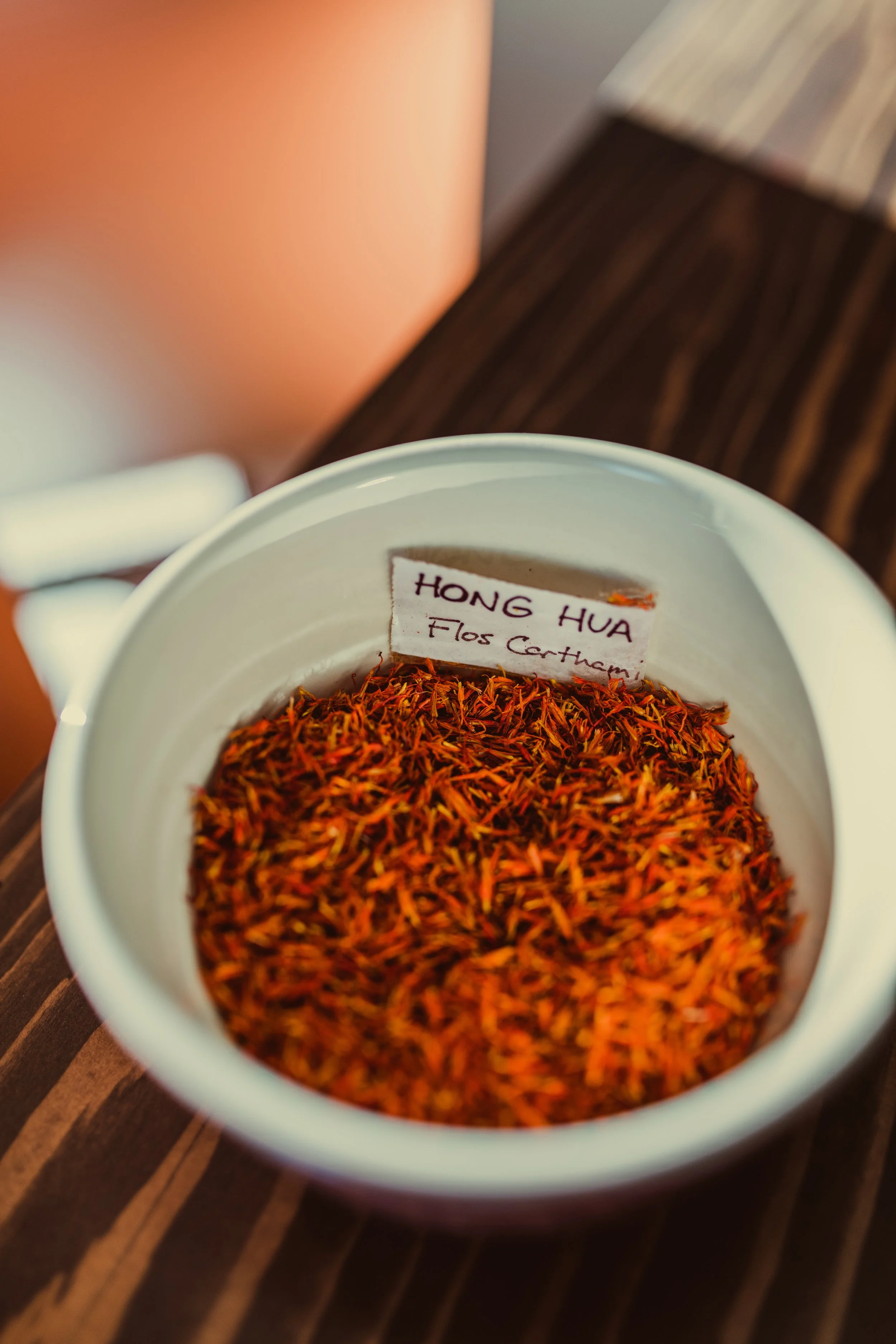 Bowl of Hong Hua (Flos Carthami) Chinese herbs used in traditional formulas to promote circulation, reduce inflammation, and restore harmony within the body.