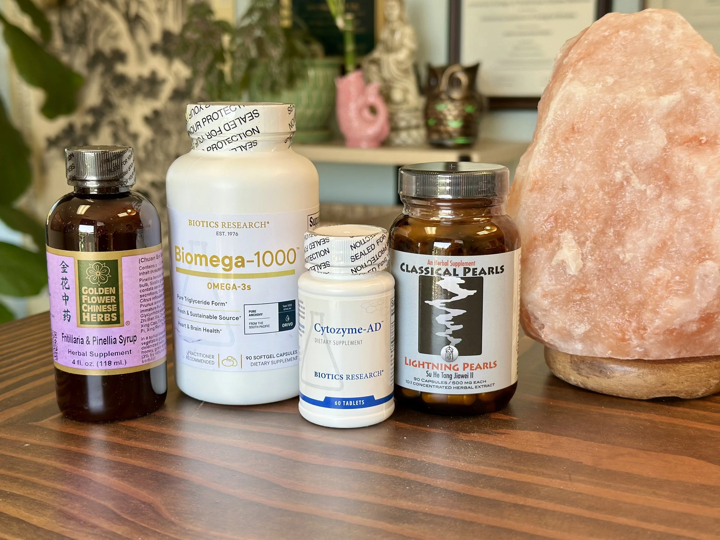 Professional-grade nutraceutical supplements displayed beside a Himalayan salt lamp, representing high-quality vitamins and botanical compounds that support natural healing and balance.
