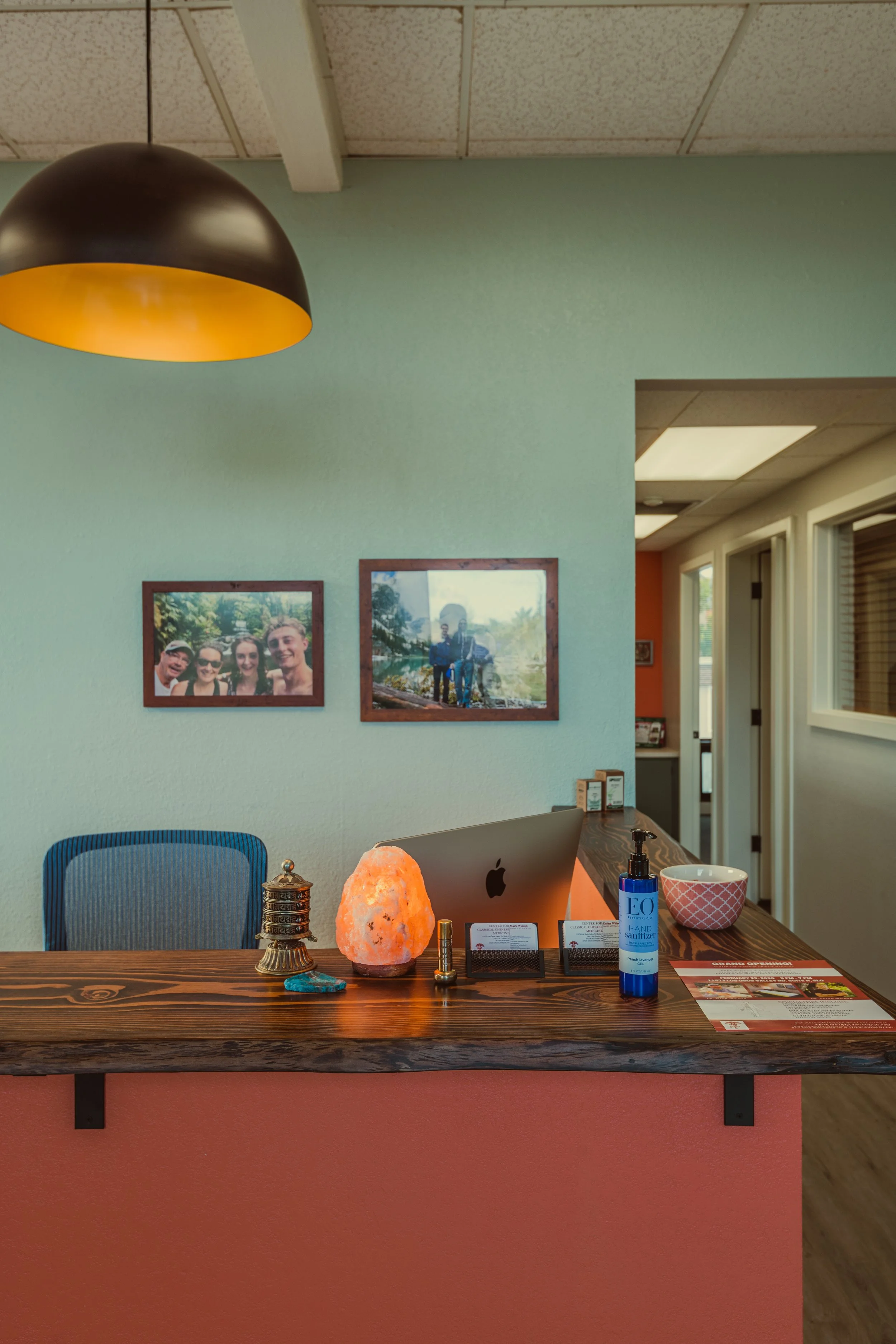 Front desk at the Center for Classical Chinese Medicine in San Luis Obispo, featuring a Himalayan salt lamp, family photos, and calming décor that reflect balance and personal care.