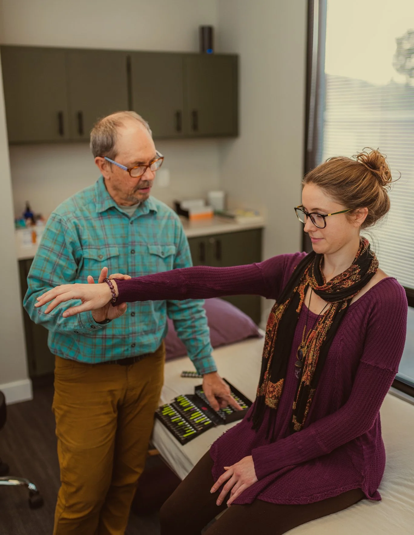 Dr. Mark Wilson performing acupuncture on a patient in a calm treatment room at the Center for Classical Chinese Medicine in San Luis Obispo.