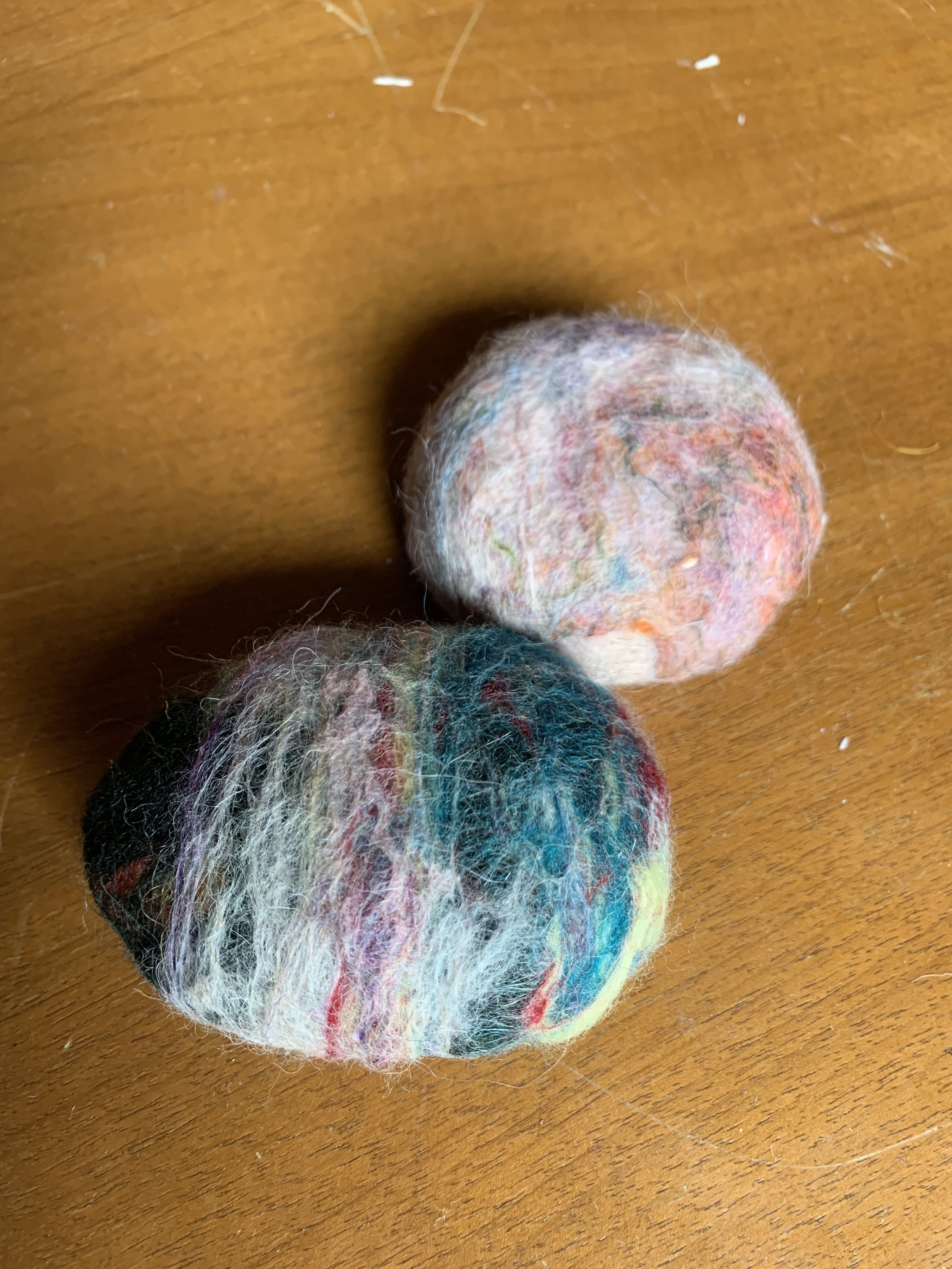 Une personne coupe un tissu blanc avec des ciseaux argentés sur une surface en bois.