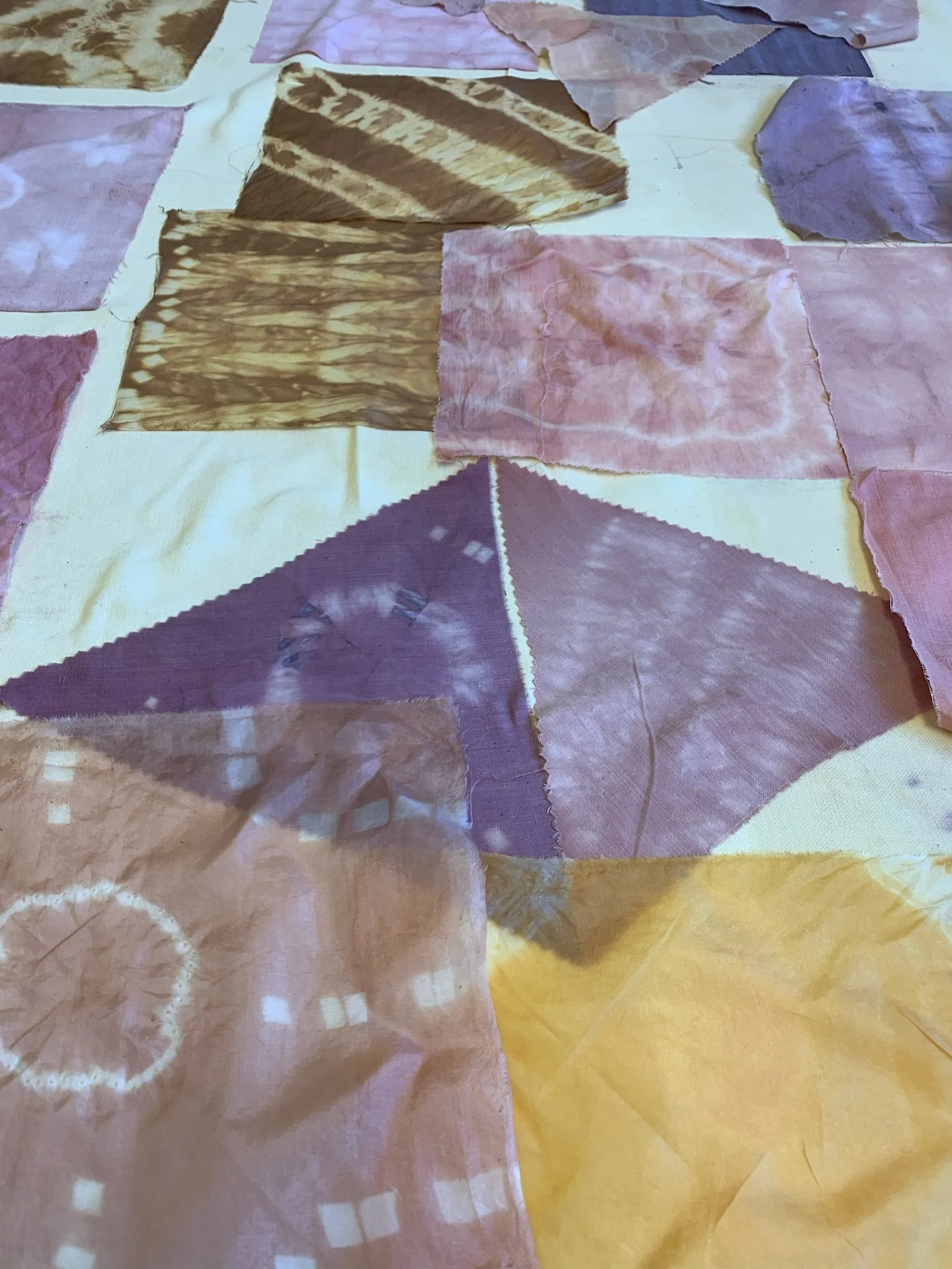 Différentes pièces de tissu colorées et teintées dans des motifs variés, disposées sur une surface