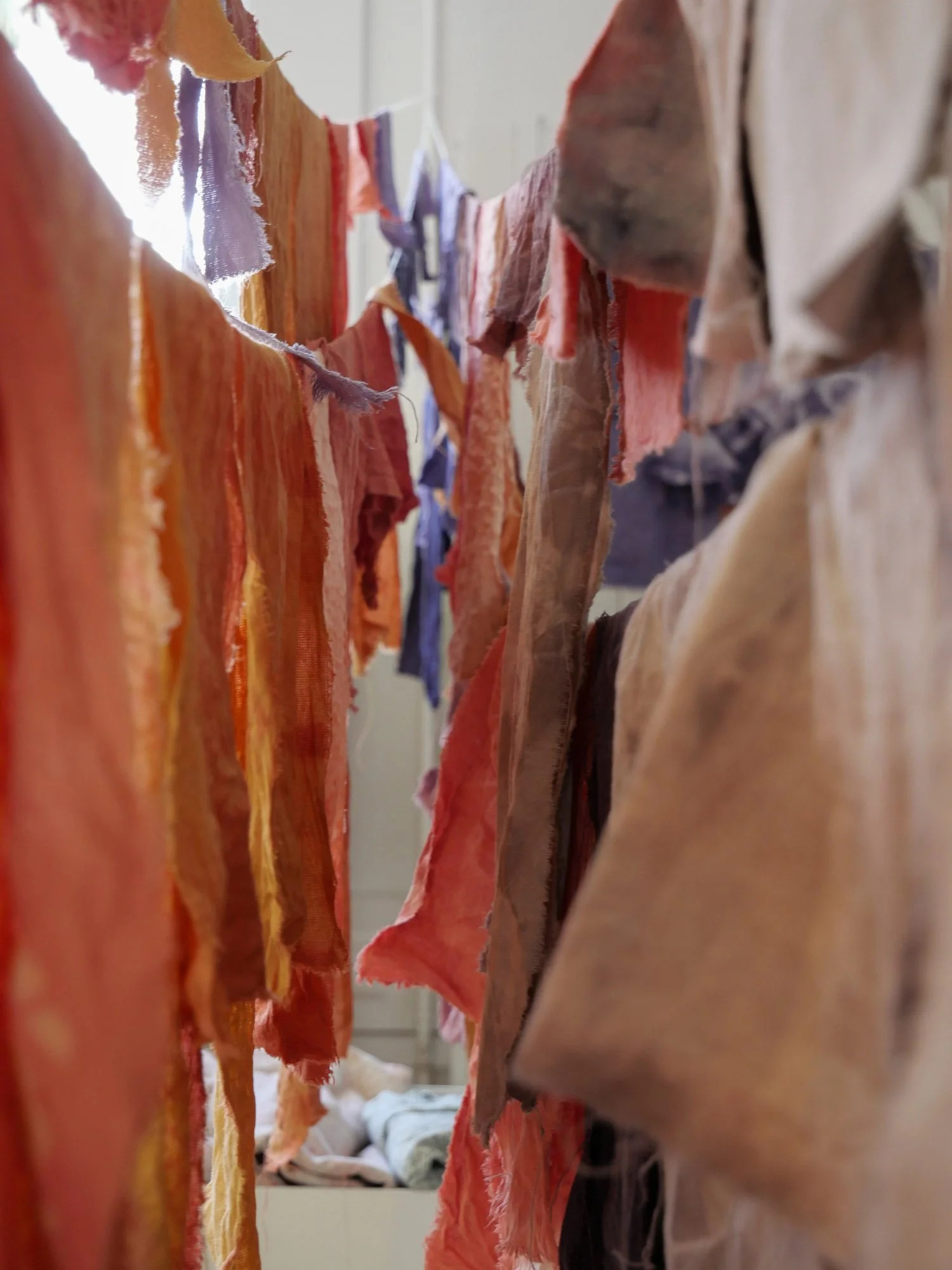 Fil de linge suspendu avec des morceaux de tissu en différentes couleurs, vue en plongée.