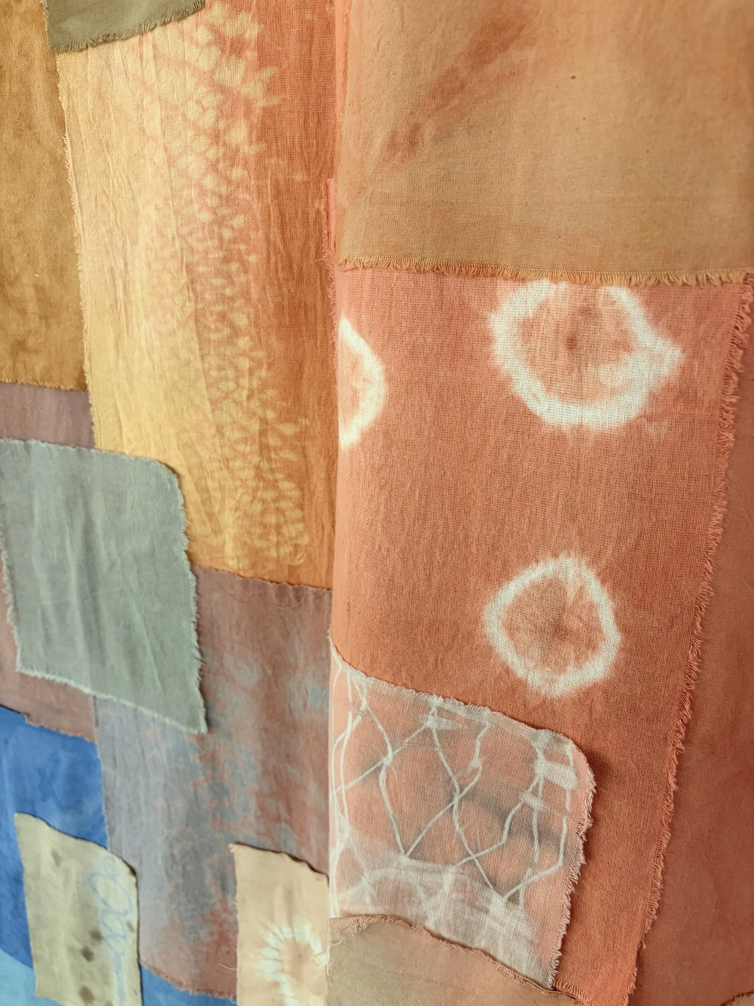 Tissus colorés avec différents motifs et textures, principalement en teintes pastel, affichés dans une composition artistique.