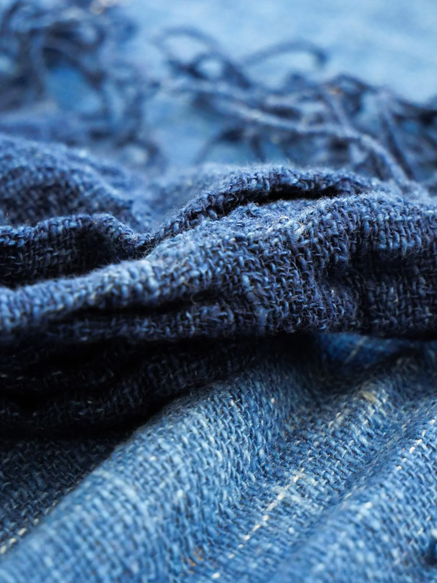Texte en denim bleu avec des plis et des textures visibles.