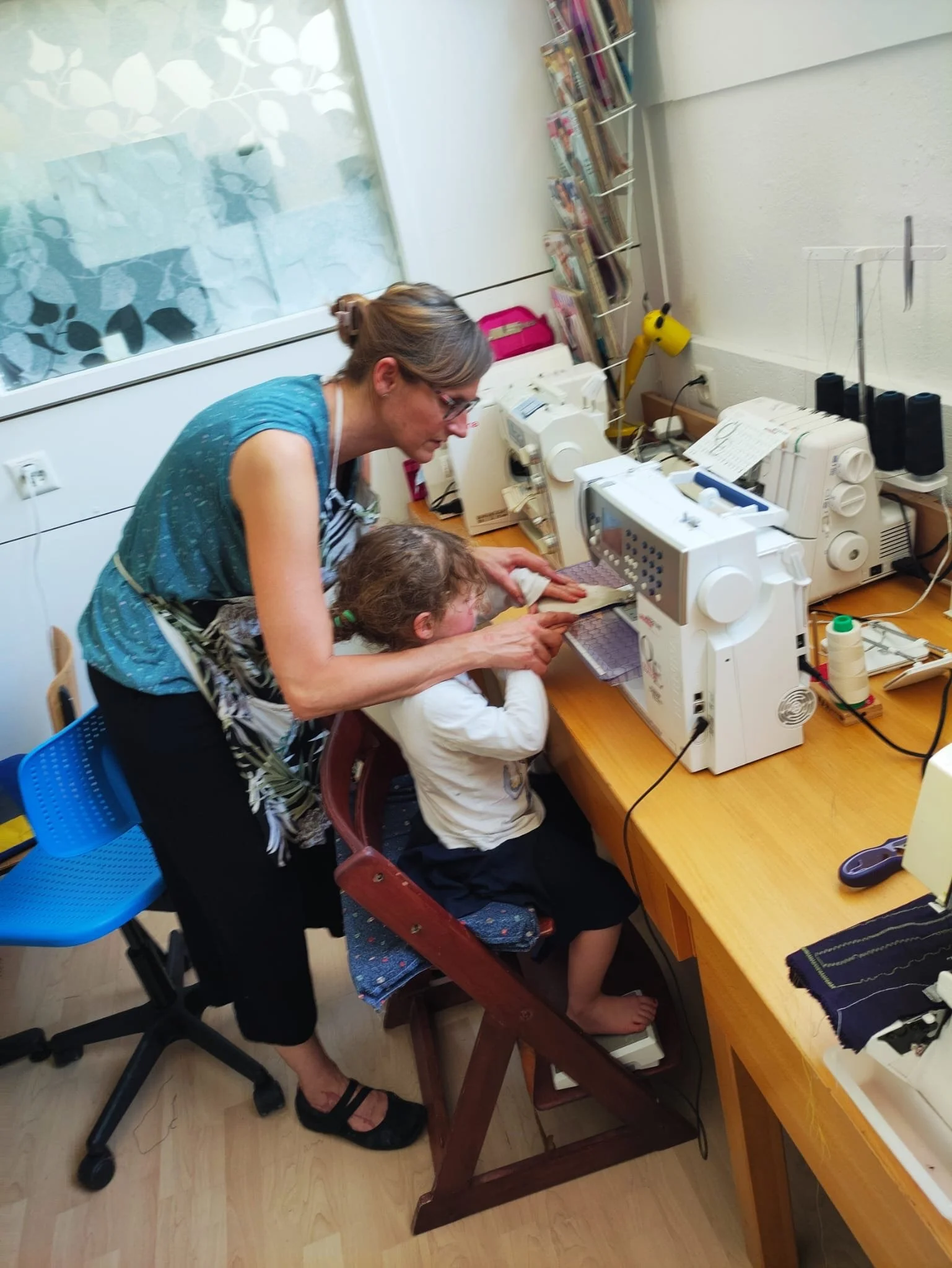 Une femme et une jeune fille utilisant une machine à coudre dans un atelier.