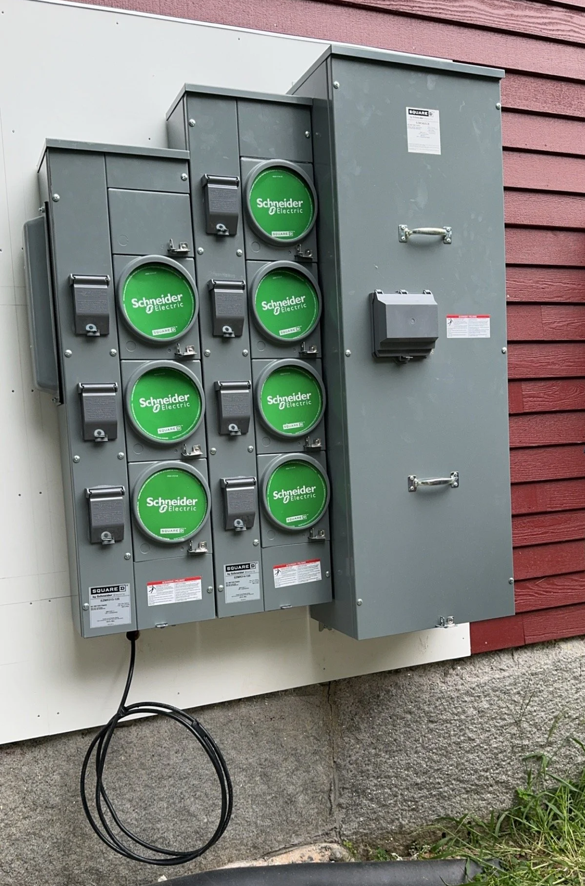 Electrical meters and panels installed on an exterior wall of a building.