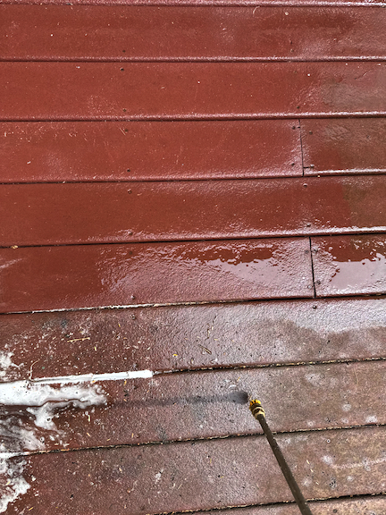 Jay of Water Works Pressure and Soft Wash using a pressure washer to clean a painted wood deck in Scituate, MA.